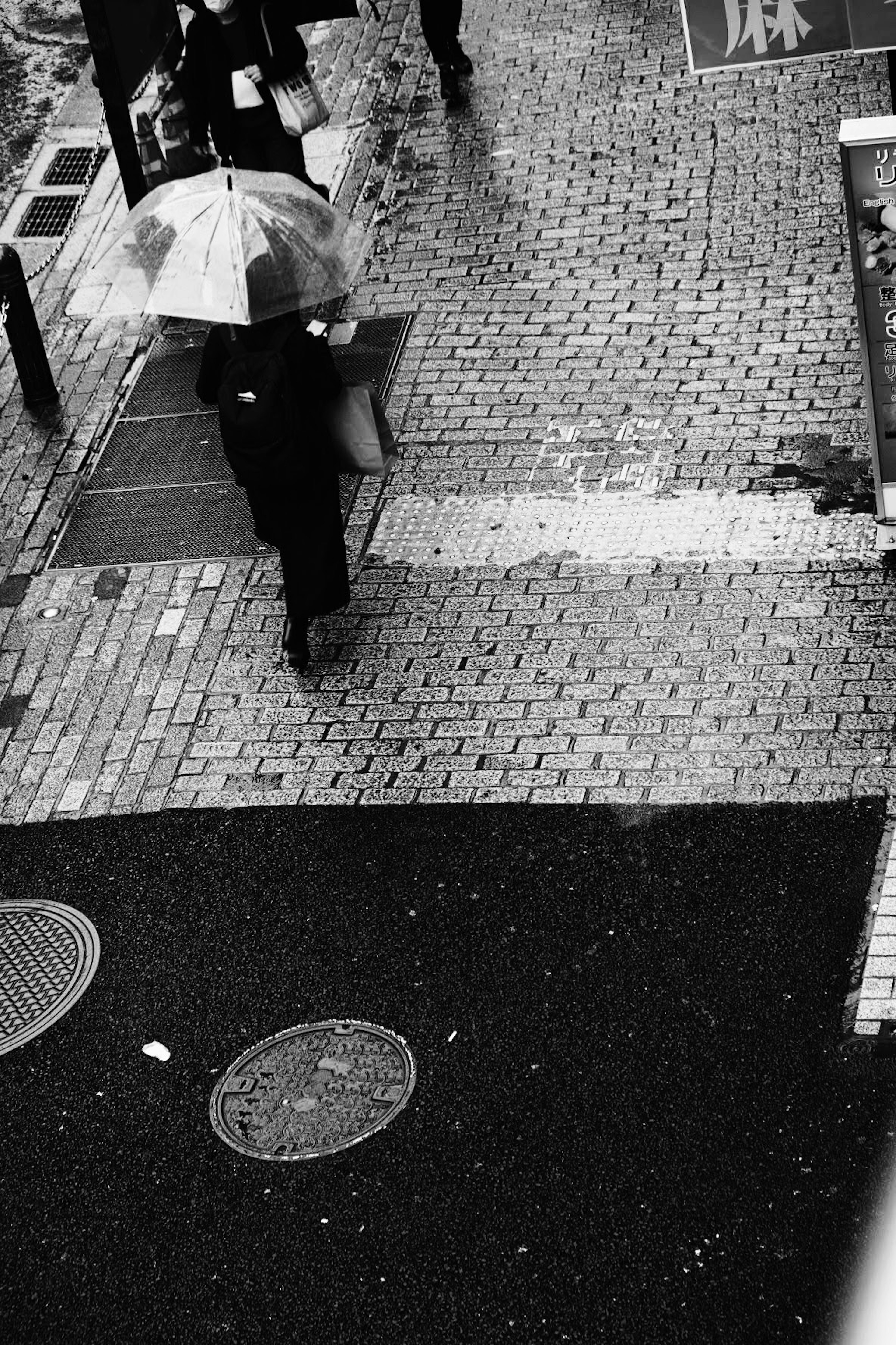 A person walking with an umbrella on a rainy street