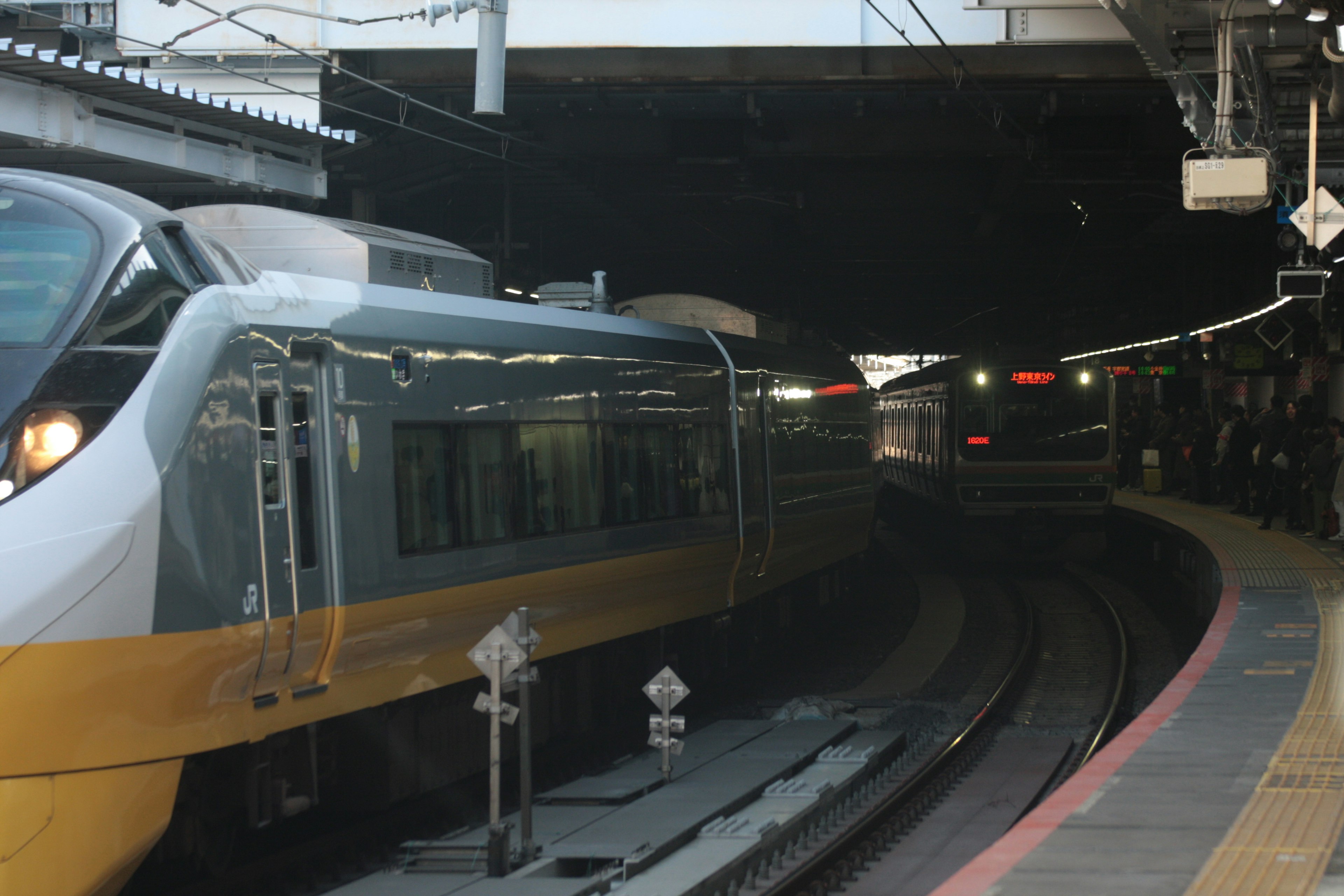 Train entering a tunnel at a station with curved tracks