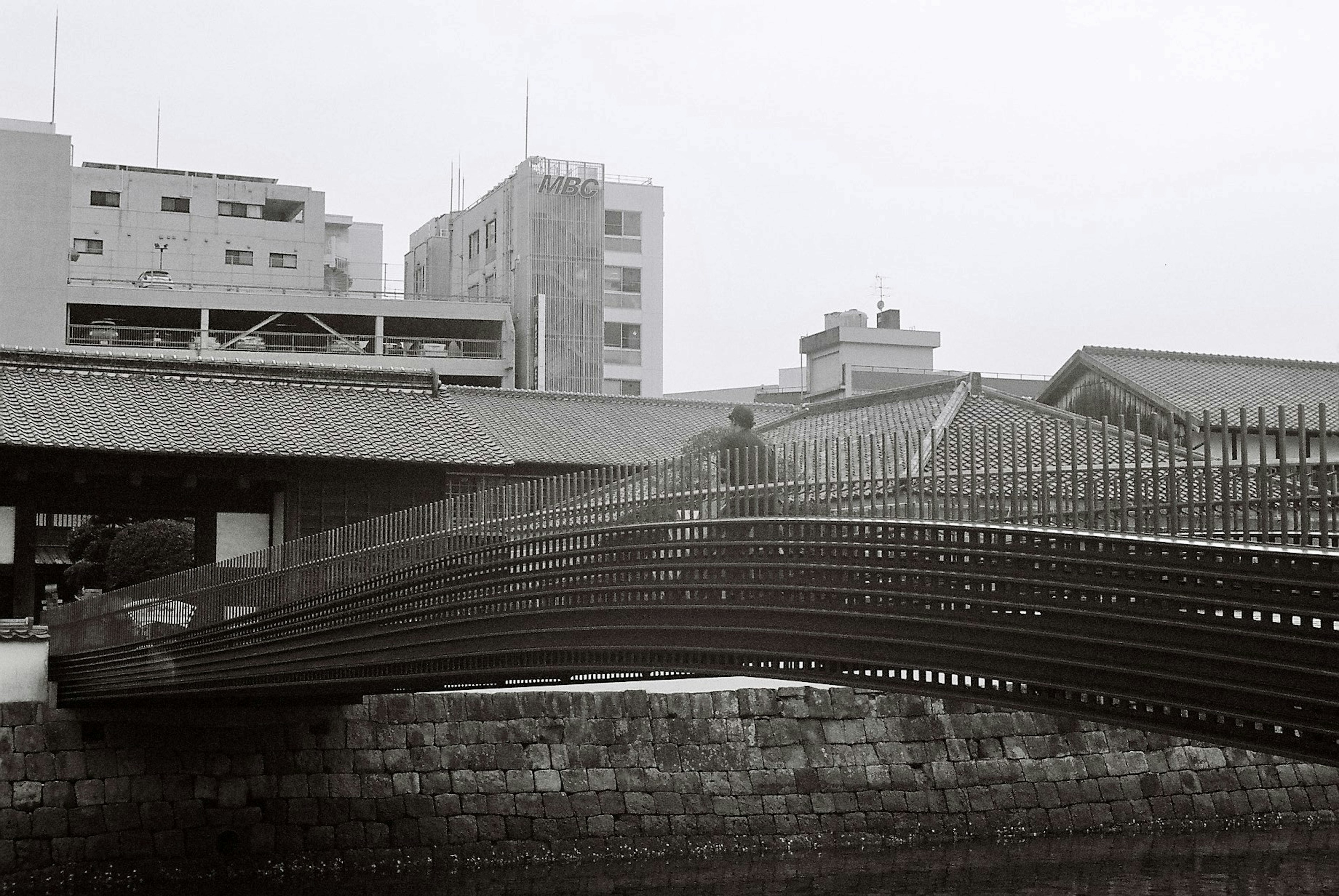 一座现代设计的桥横跨河流，与周围建筑和谐相融