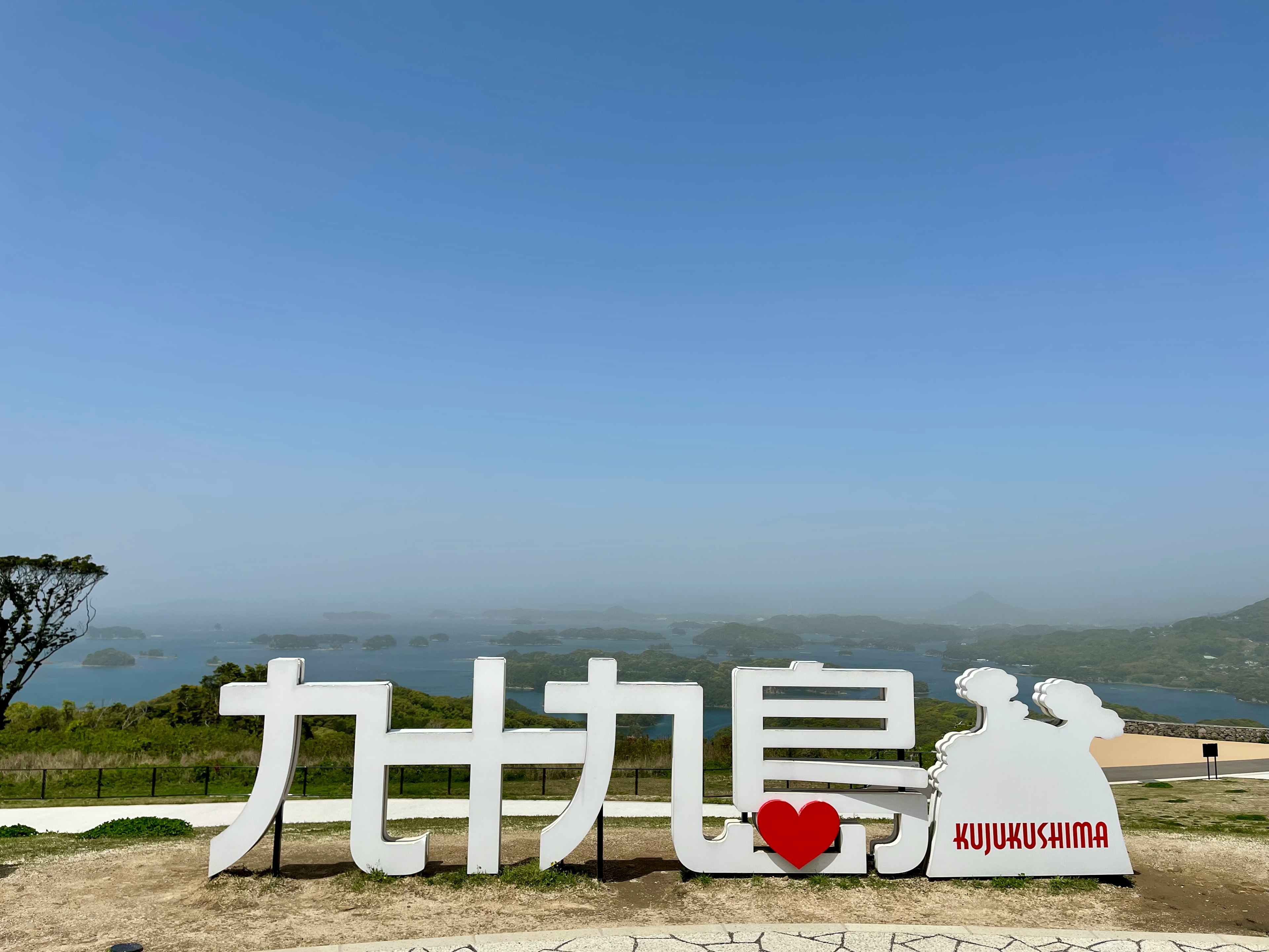 Papan besar untuk Kujukushima di bawah langit biru cerah