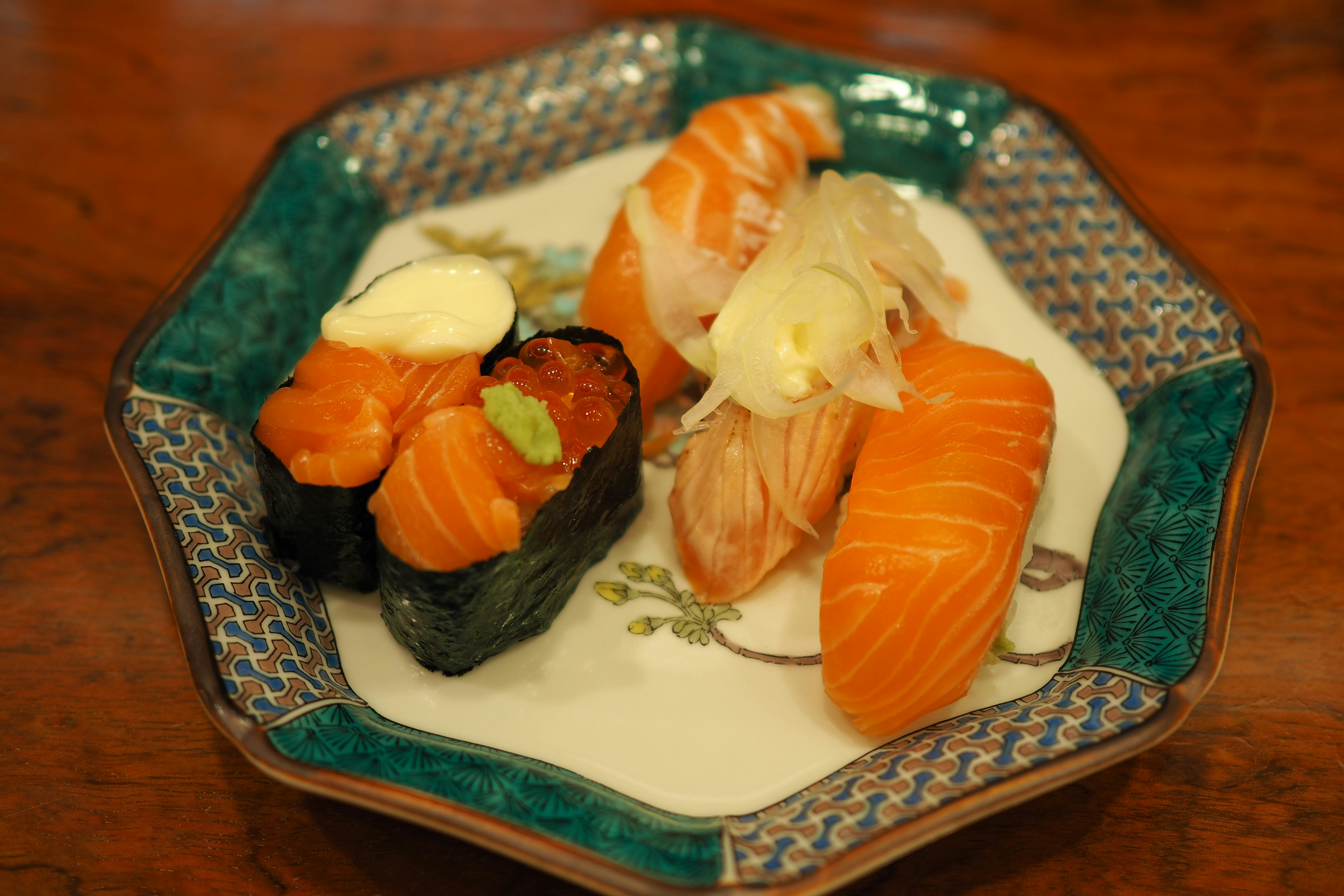 Ein schöner Teller mit buntem Sushi, darunter Lachs und Beilagen