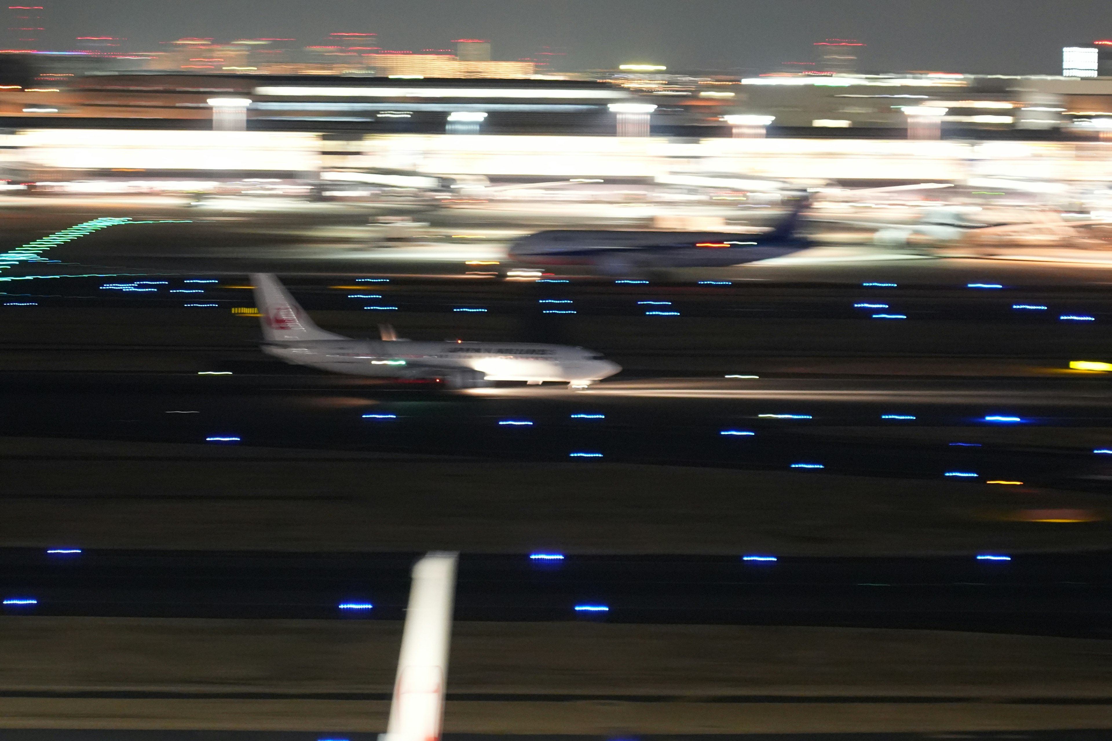 Imagen de un avión rodando en una pista por la noche