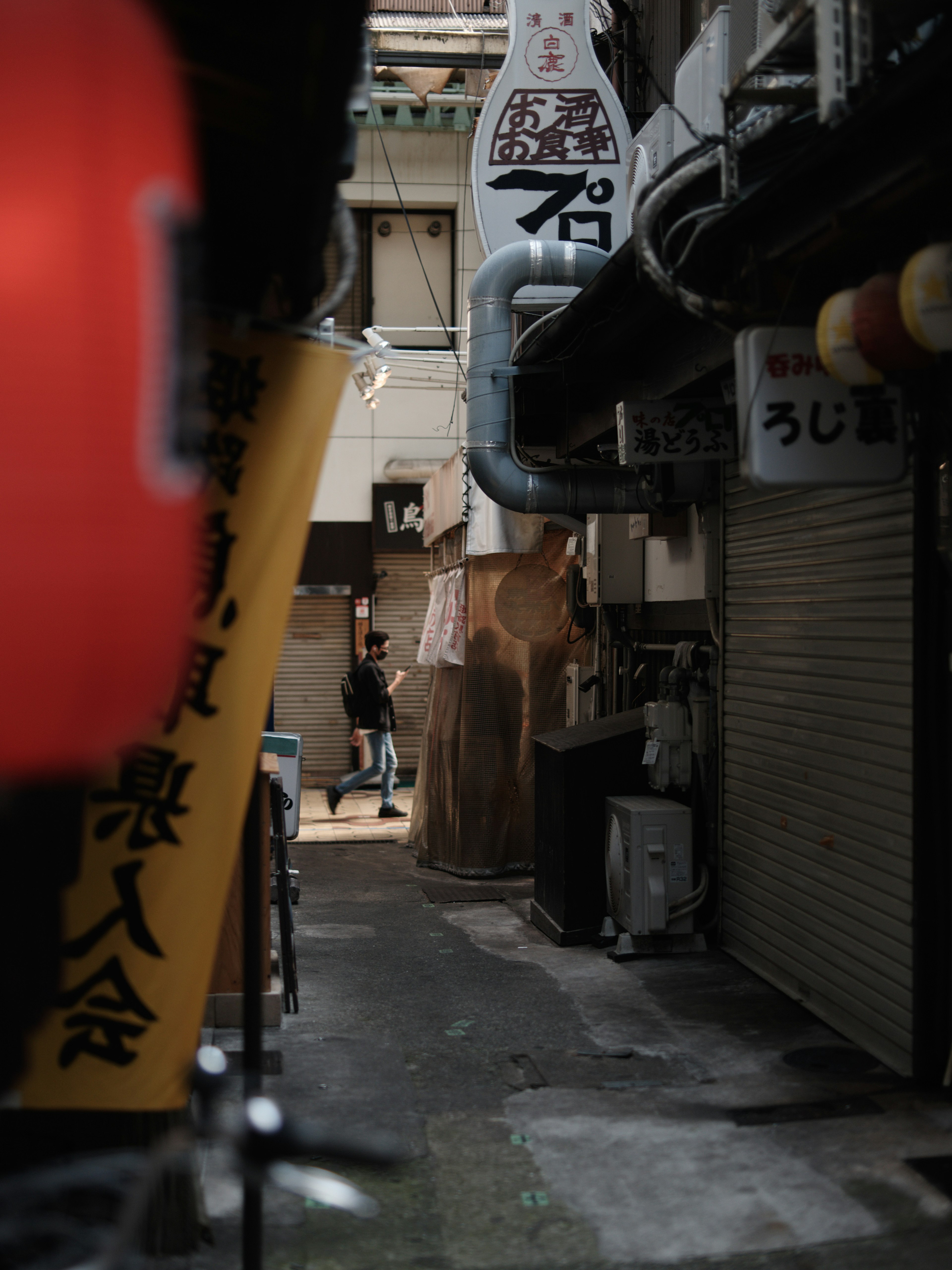 Narrow alley featuring restaurant signs and a dimly lit atmosphere