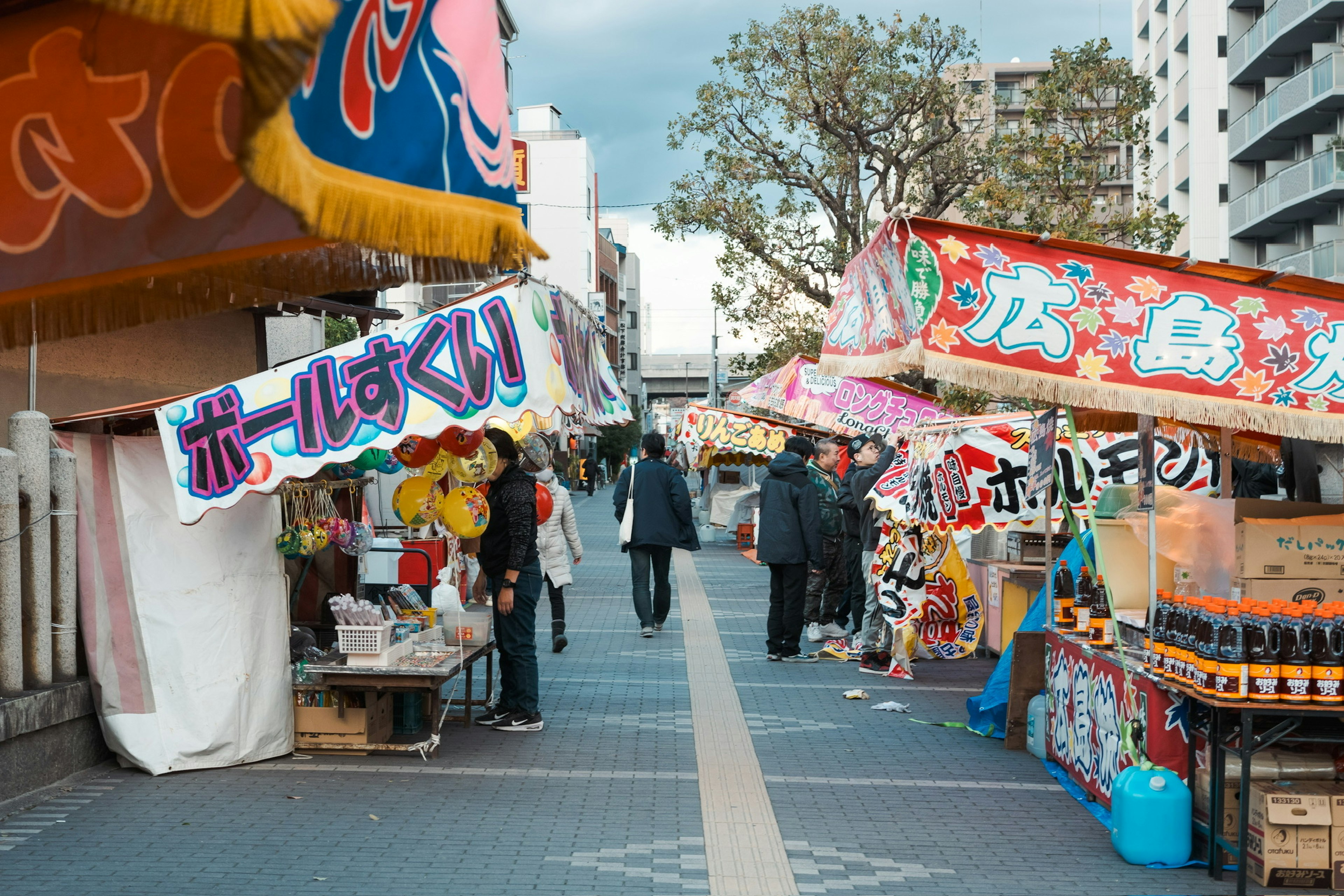 Lebendige Straßenszene mit bunten Ständen und Menschen, die gehen