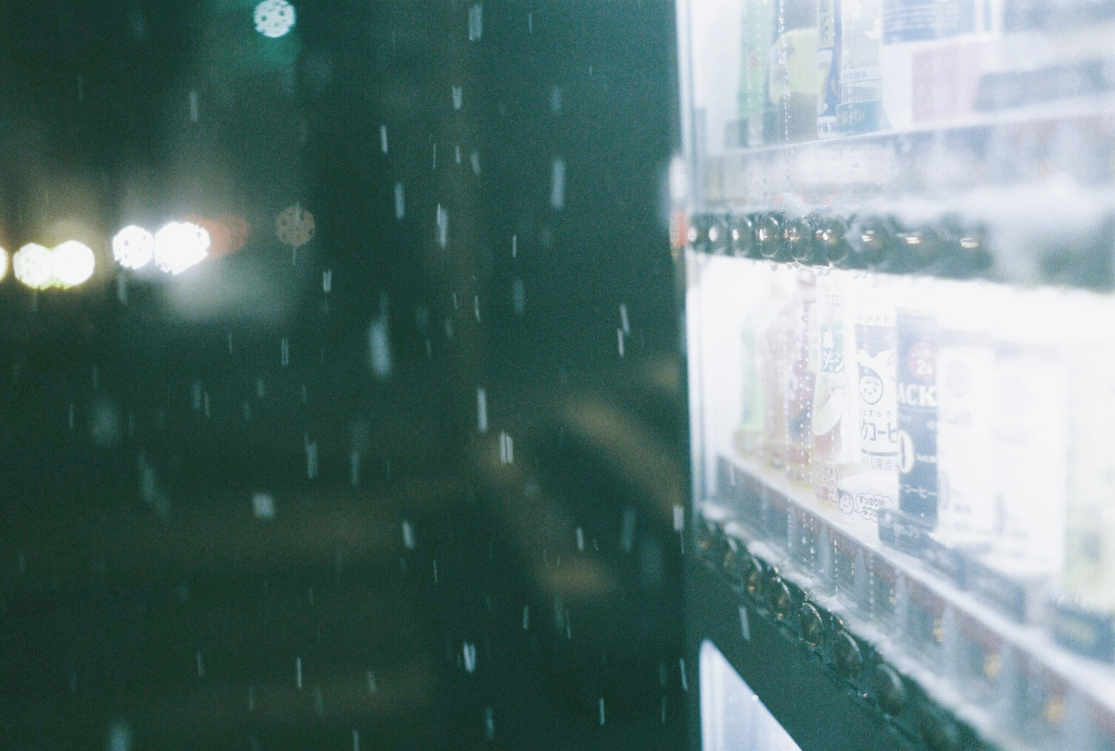 Night scene featuring a vending machine and falling snow