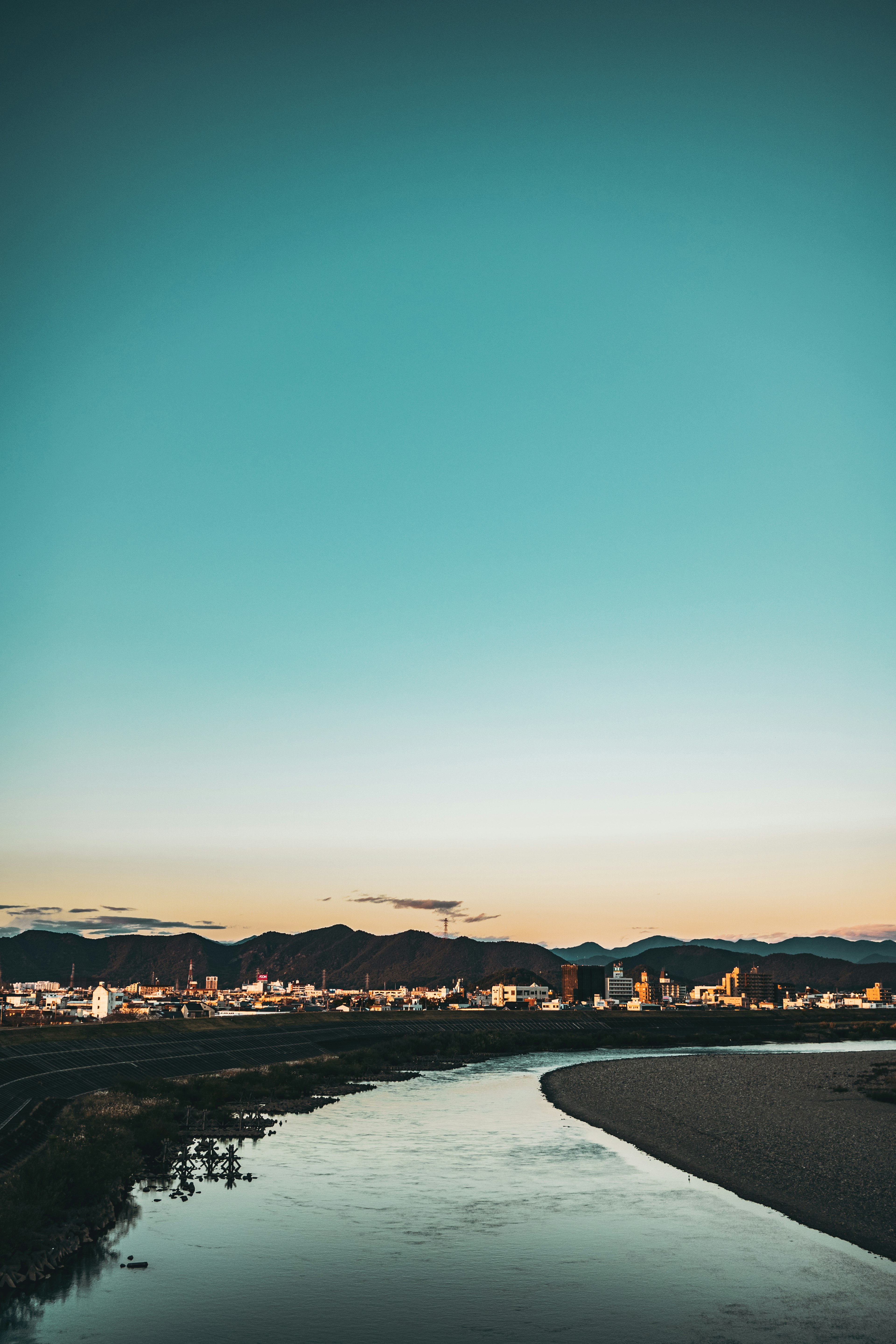 青空と山々を背景にした川の風景