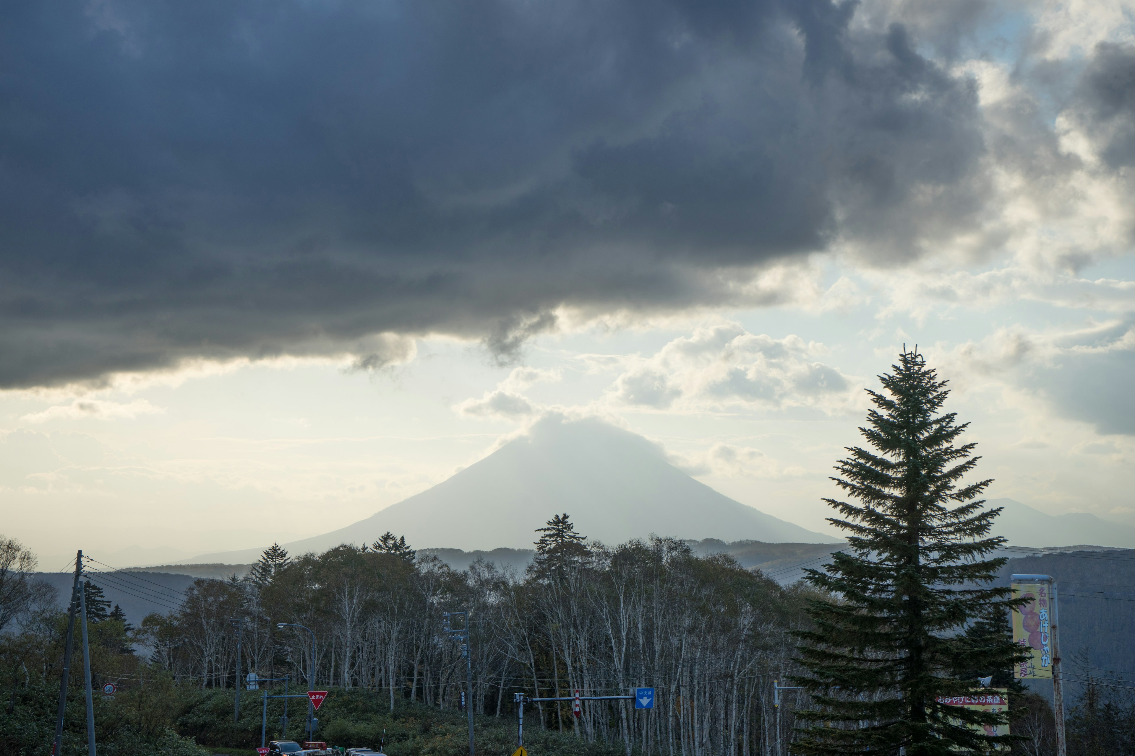 Una vista panoramica di una montagna circondata da nuvole e alberi