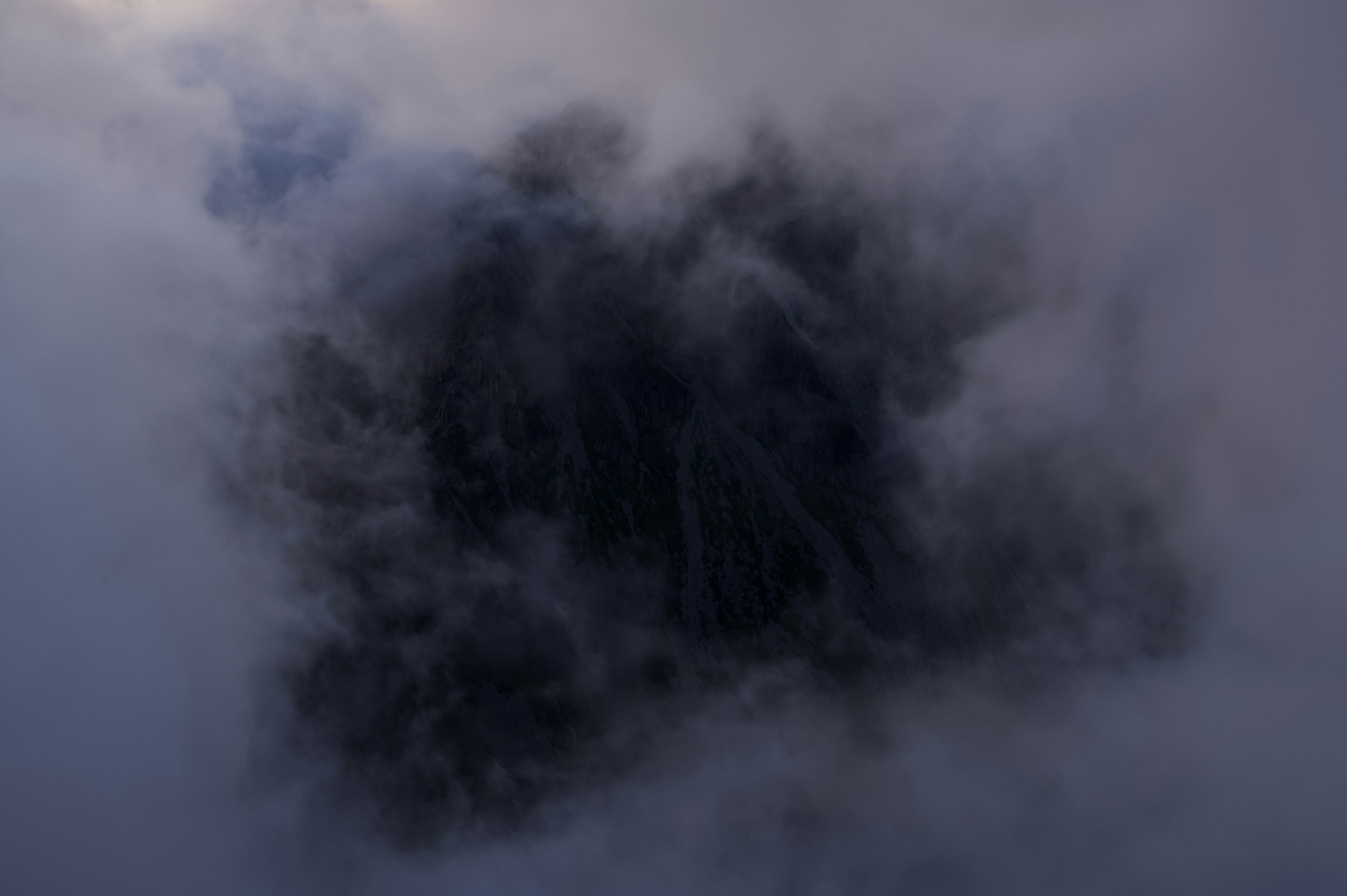 Silhouette d'une montagne cachée dans des nuages sombres