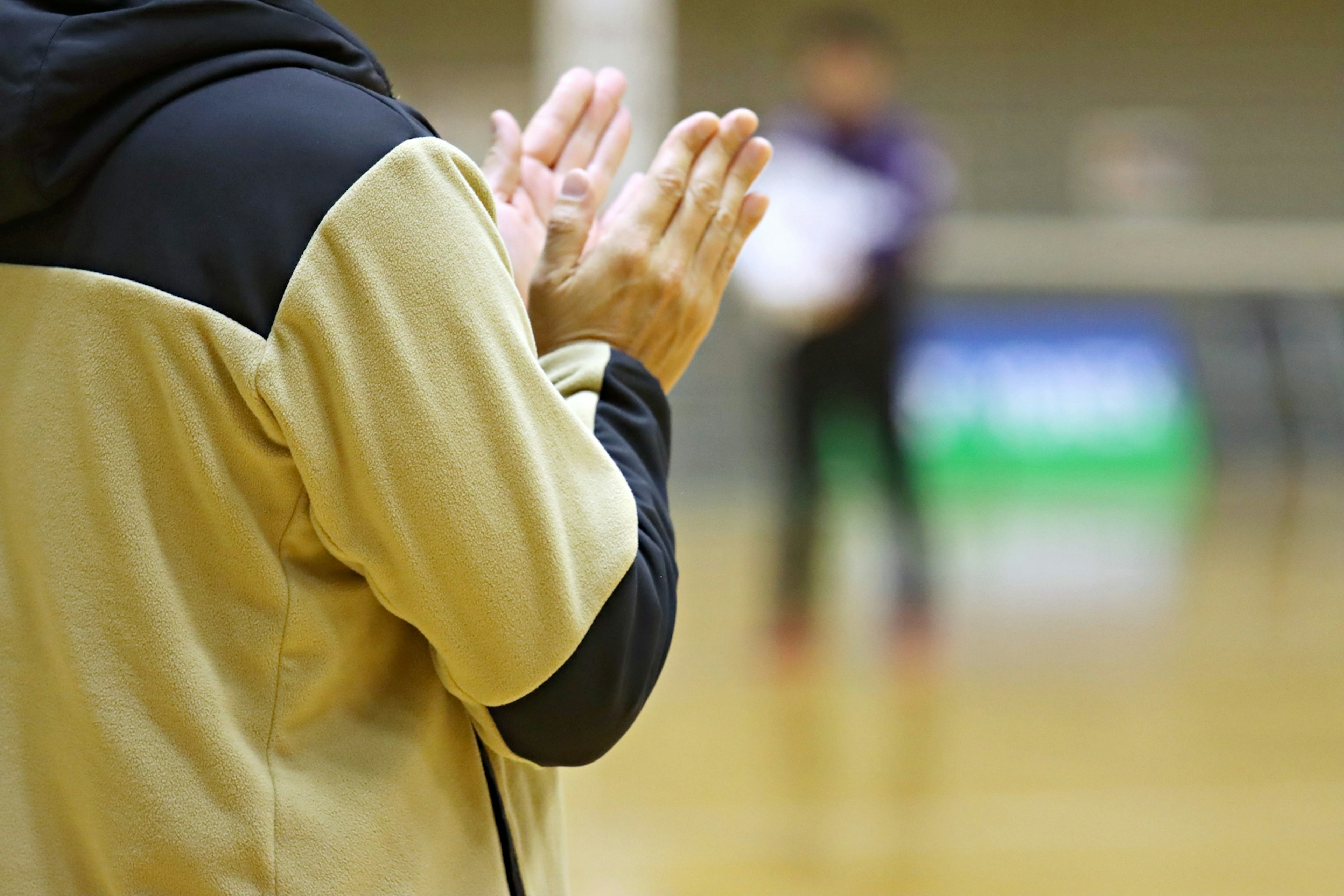 Person clapping with blurred background of a sports event