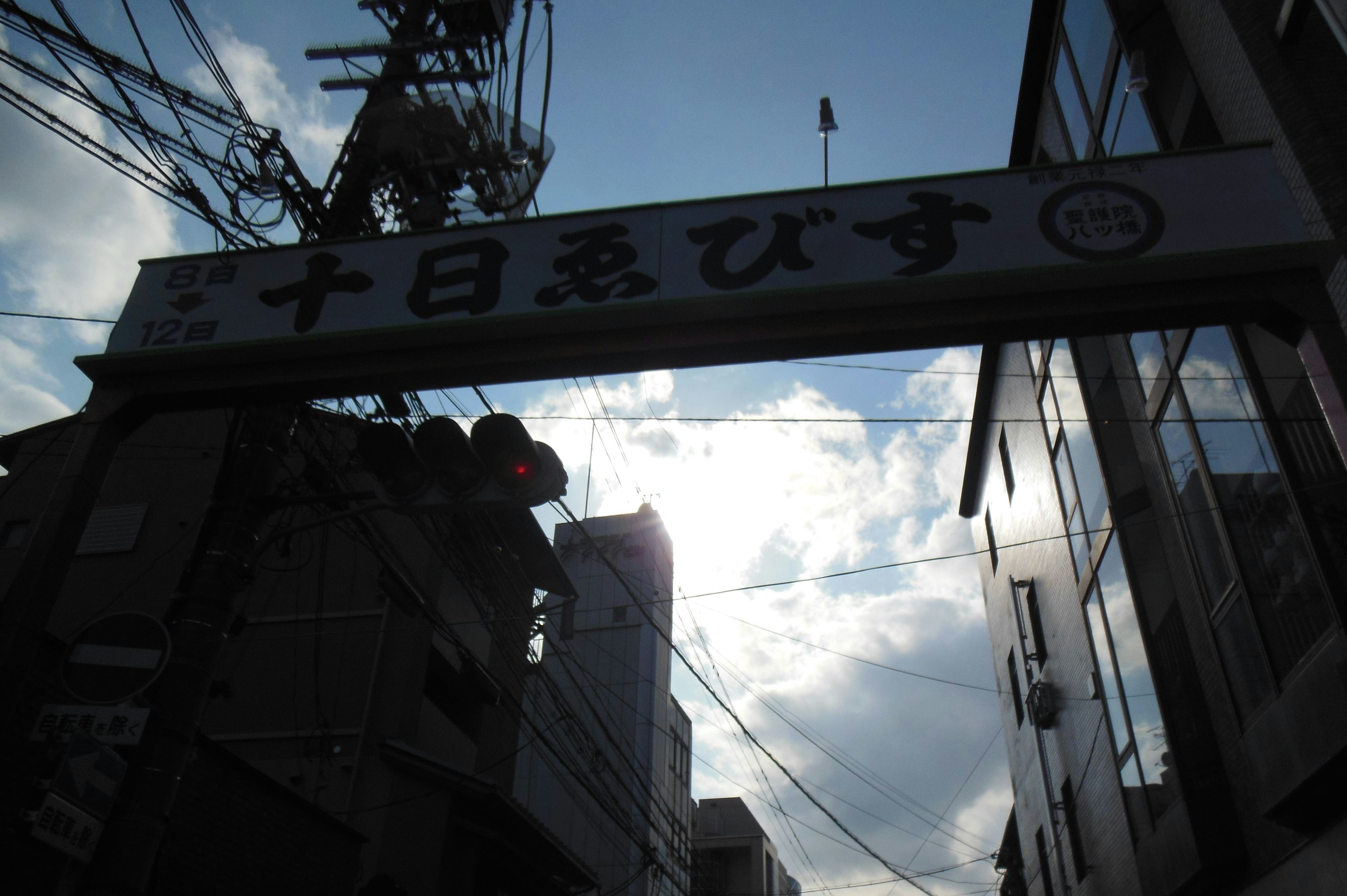 Archway sign of a shopping street under a cloudy sky