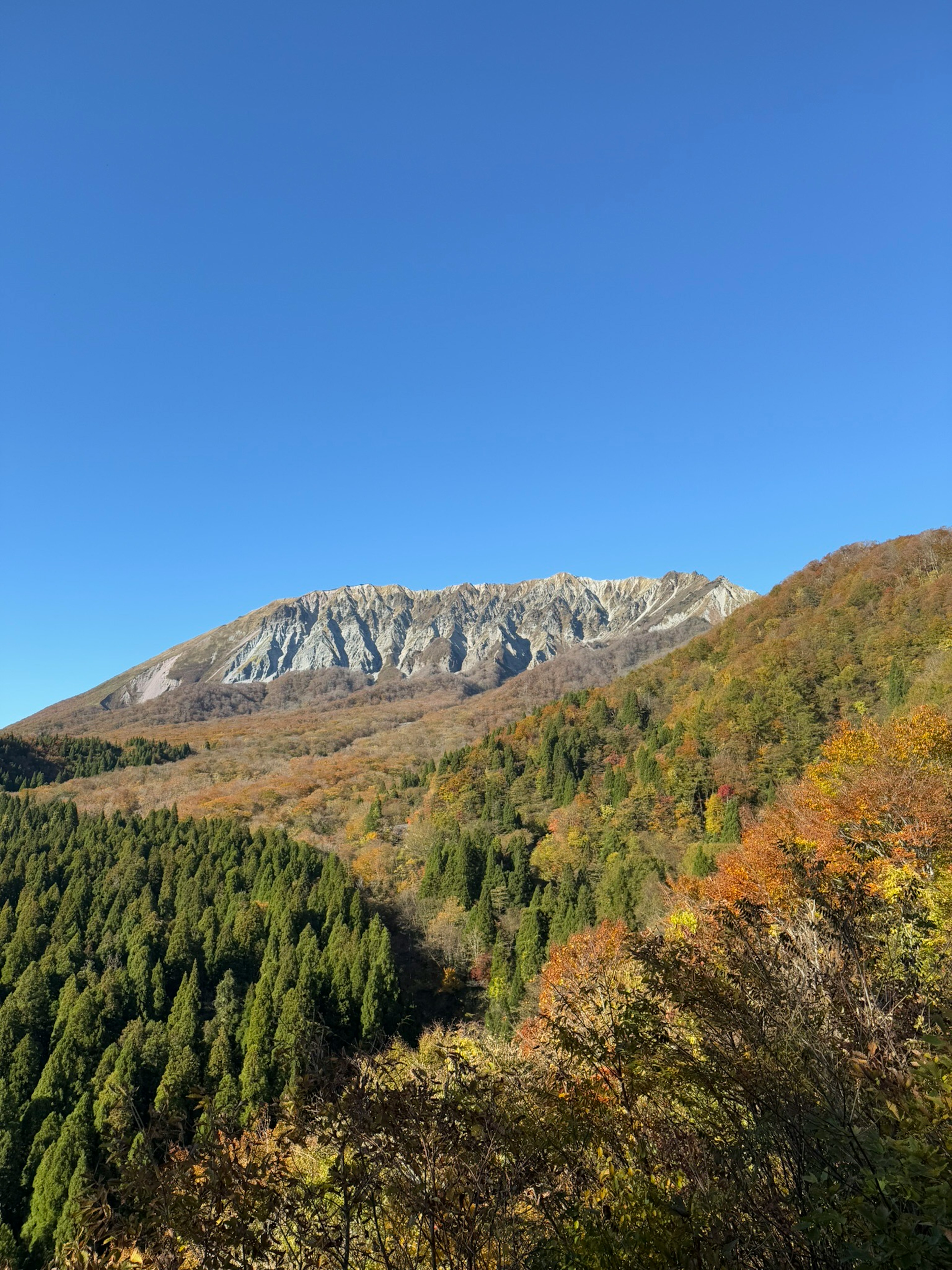 青空と紅葉の山々を背景にした美しい風景