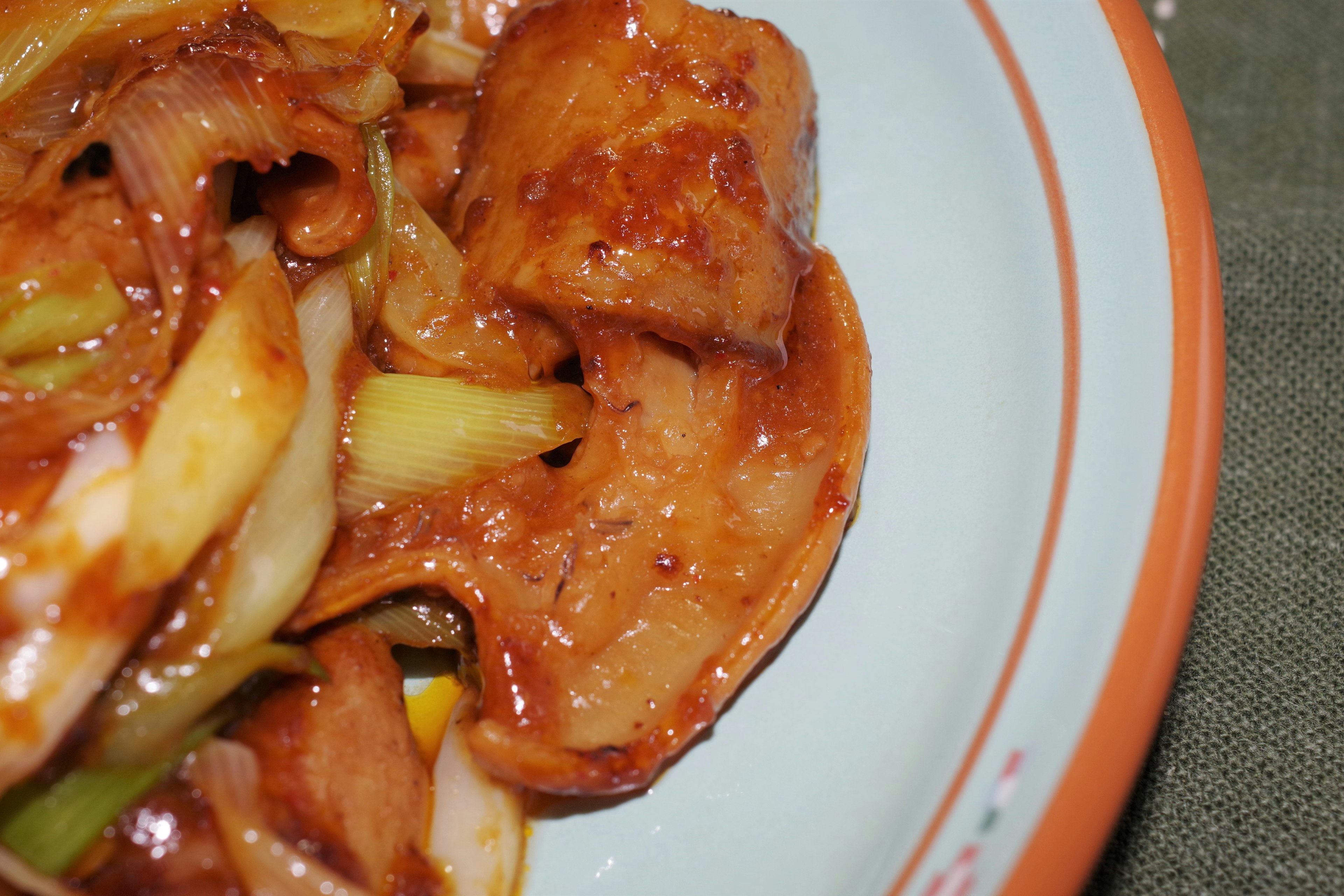 Close-up of stir-fried pork with vegetables served in a bowl