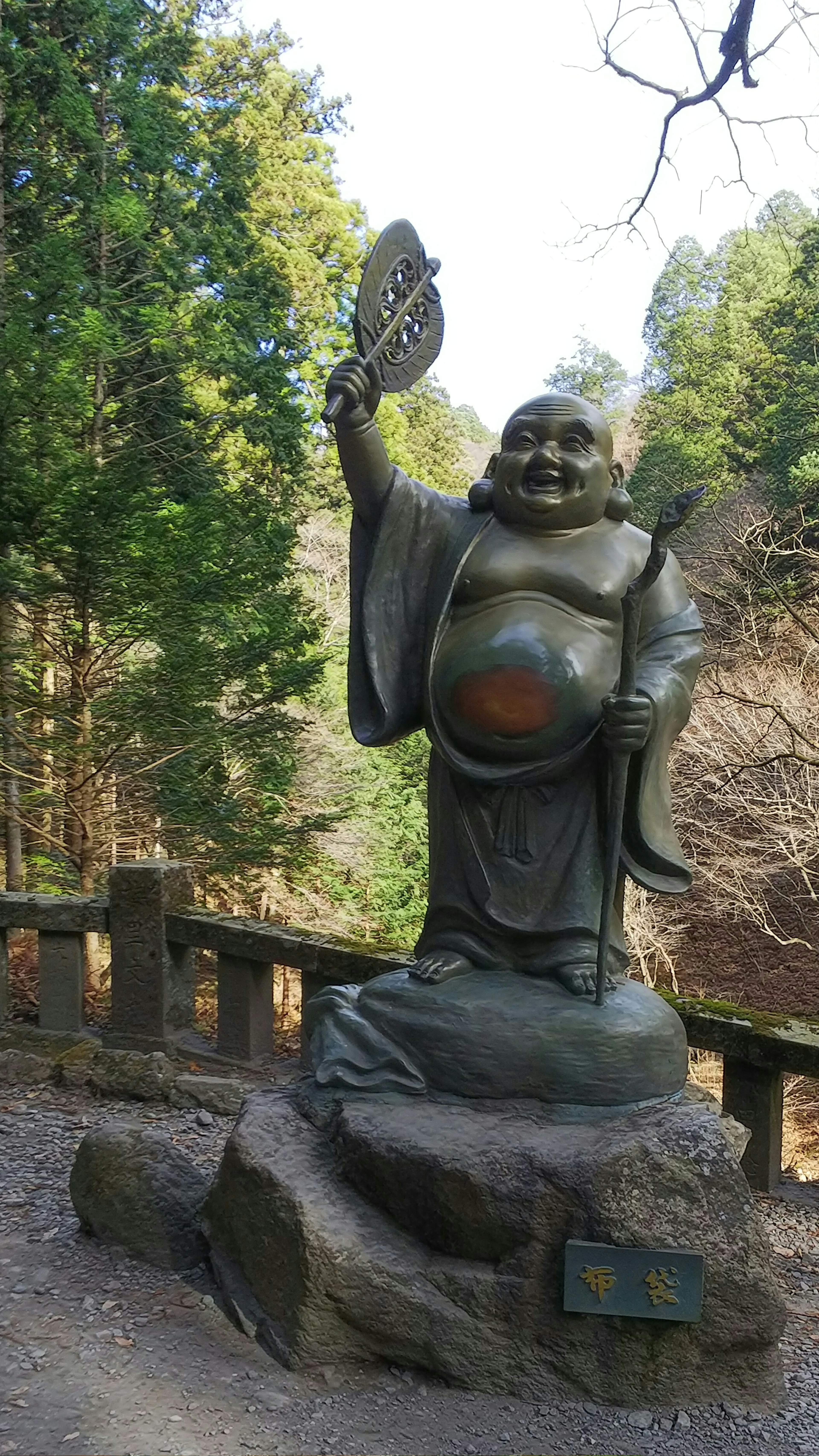 Una gran estatua de una deidad de la suerte de pie en el bosque