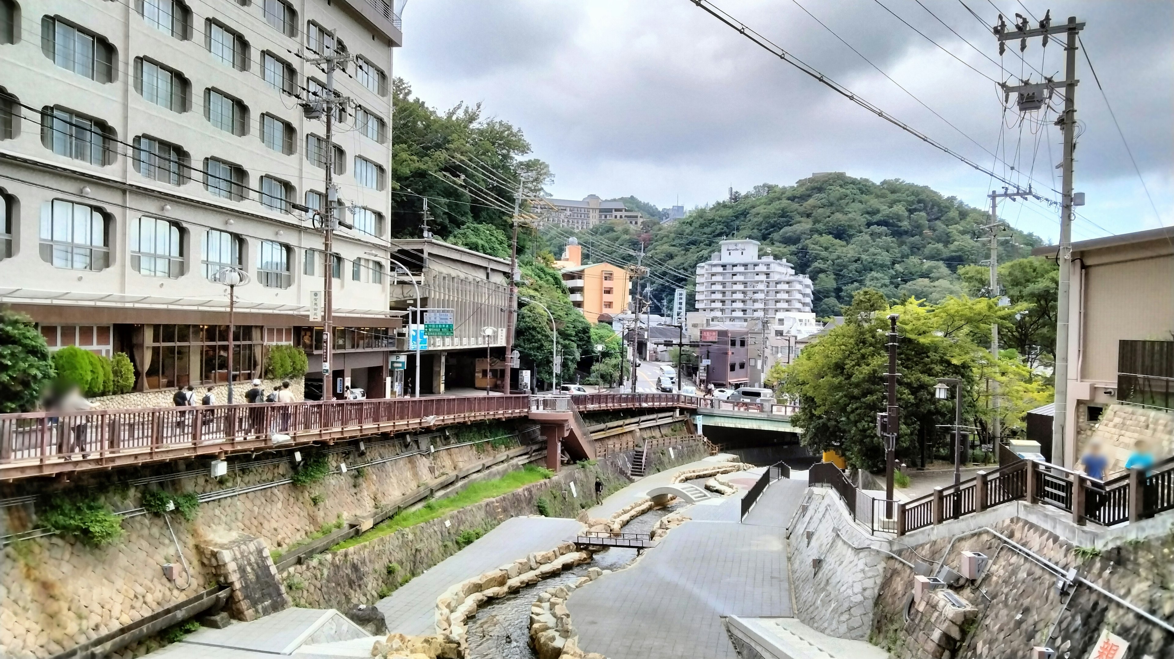 Vista escénica de una ciudad termal con hoteles junto al río y montañas verdes