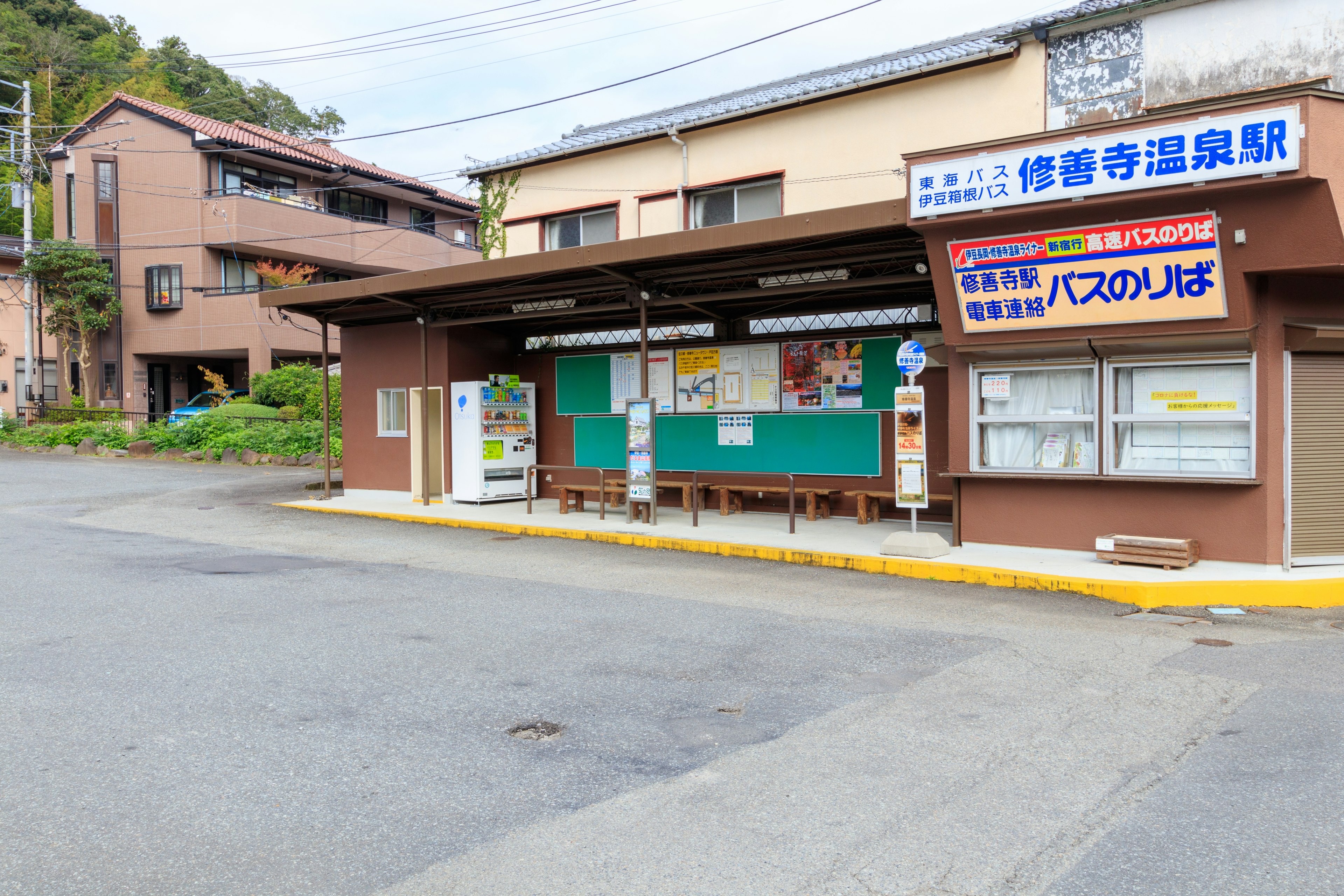 田舎のバス停と周囲の建物が見える風景