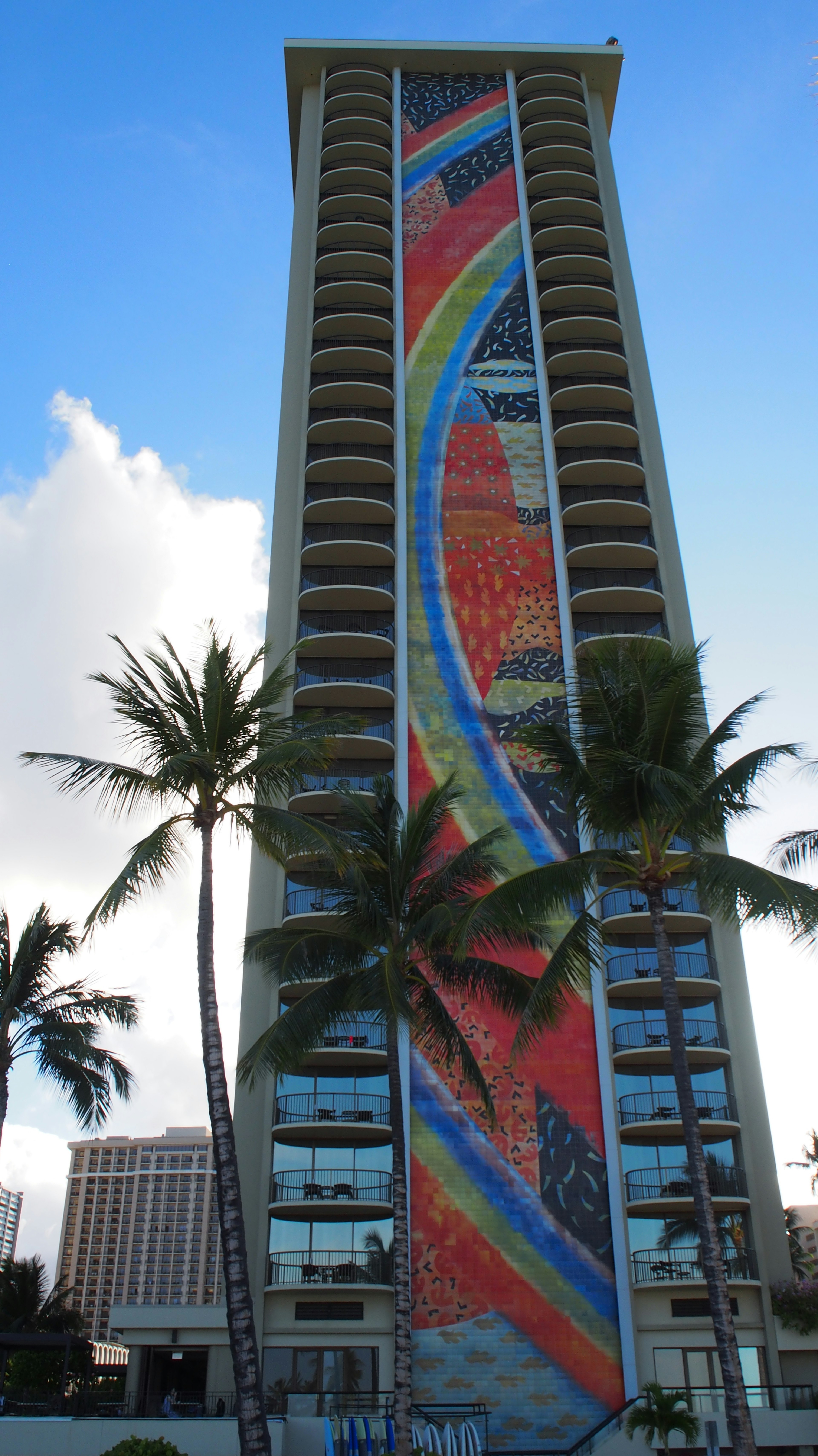 Colorful mural on the exterior of a high-rise building in a beach setting