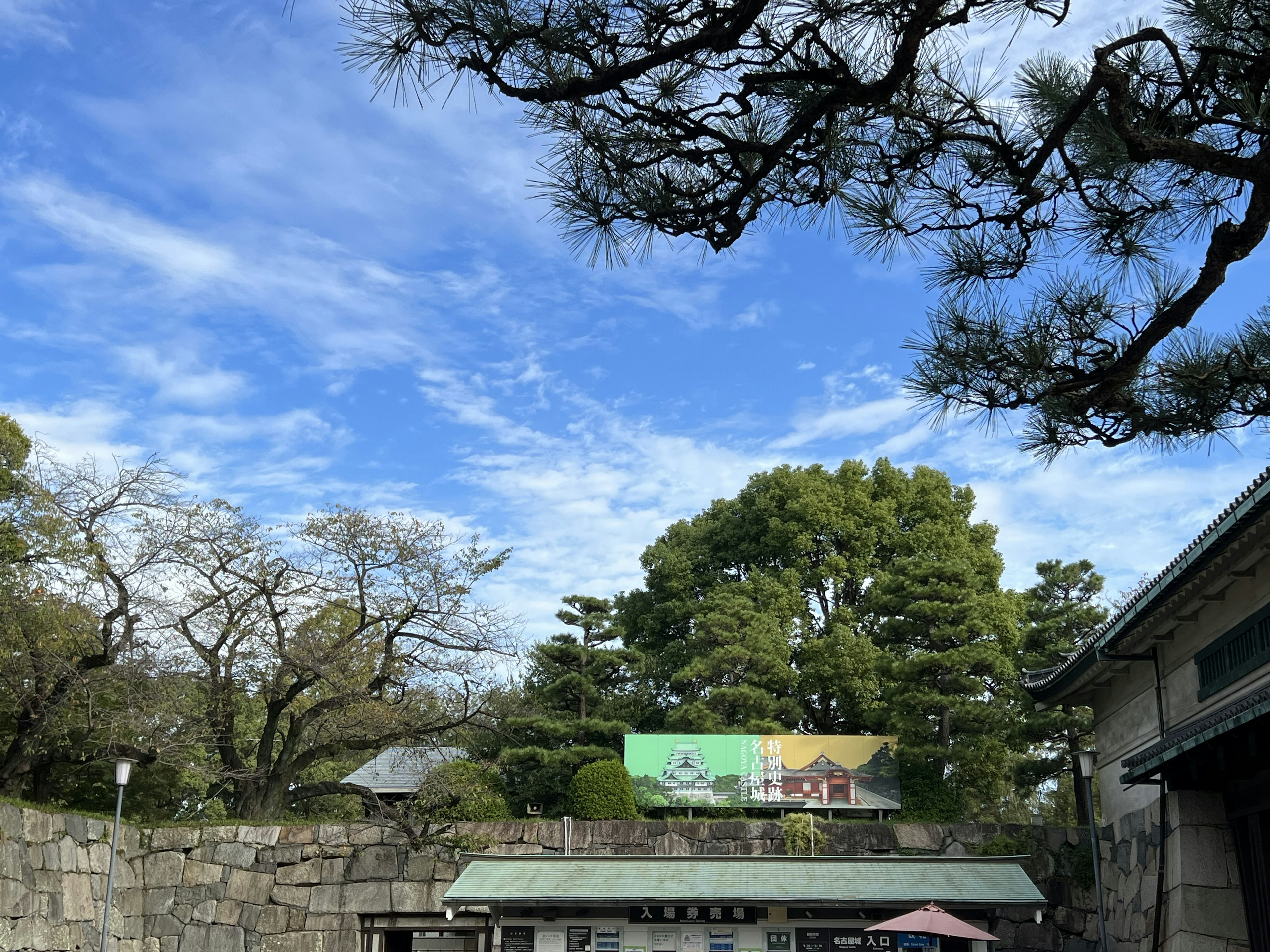 Scenic view with blue sky and green trees part of a walled garden