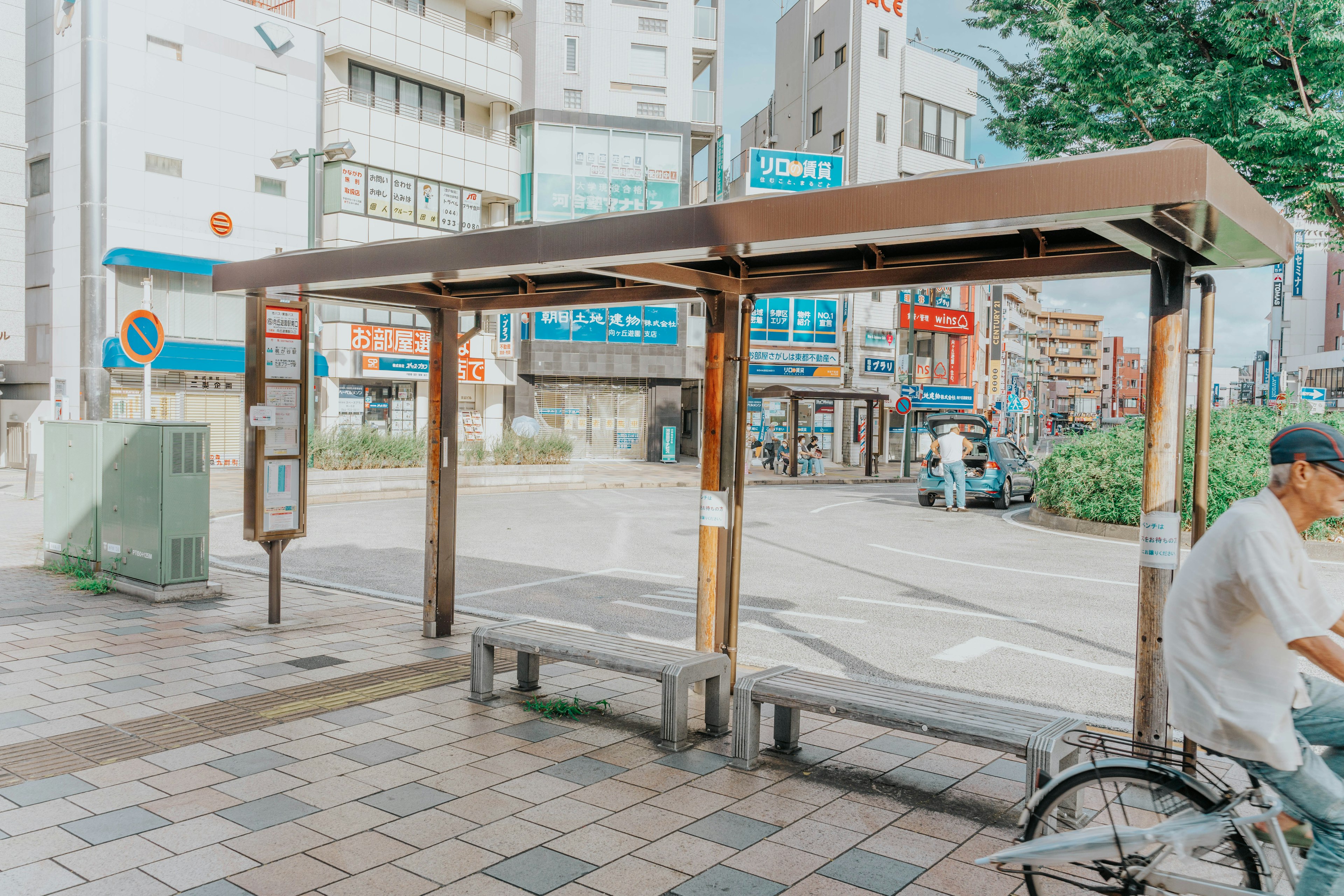 A bus stop with surrounding buildings and greenery