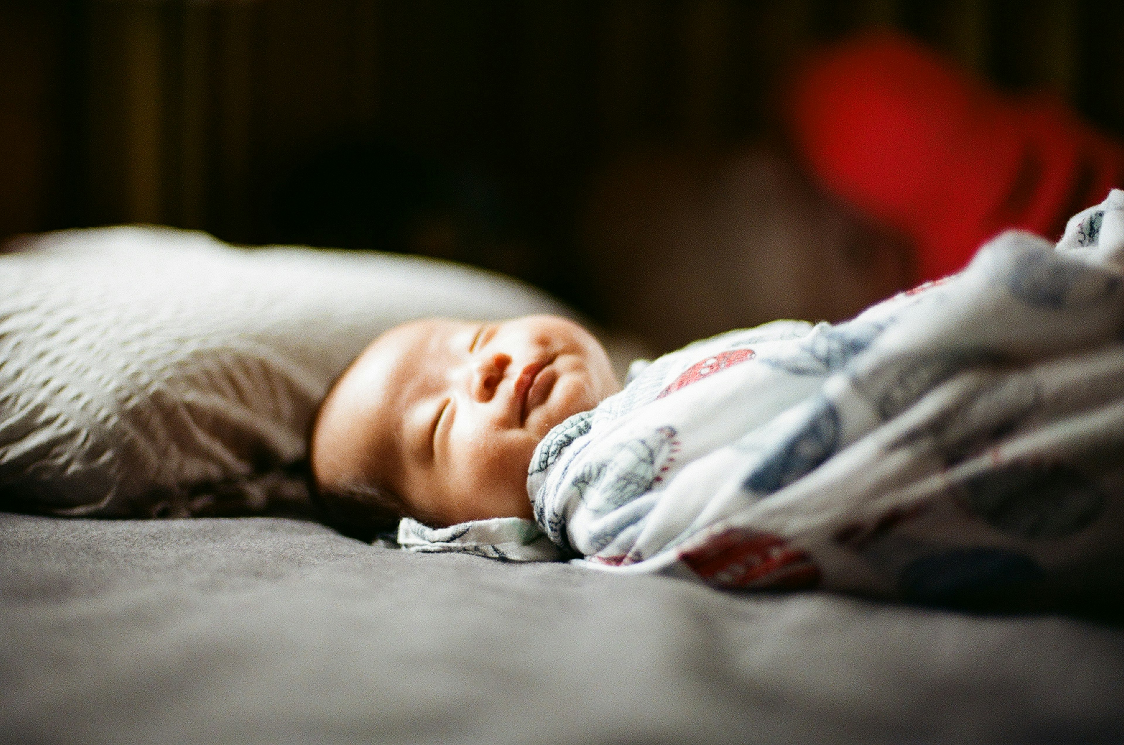 A baby peacefully sleeping on a pillow with a cozy blanket