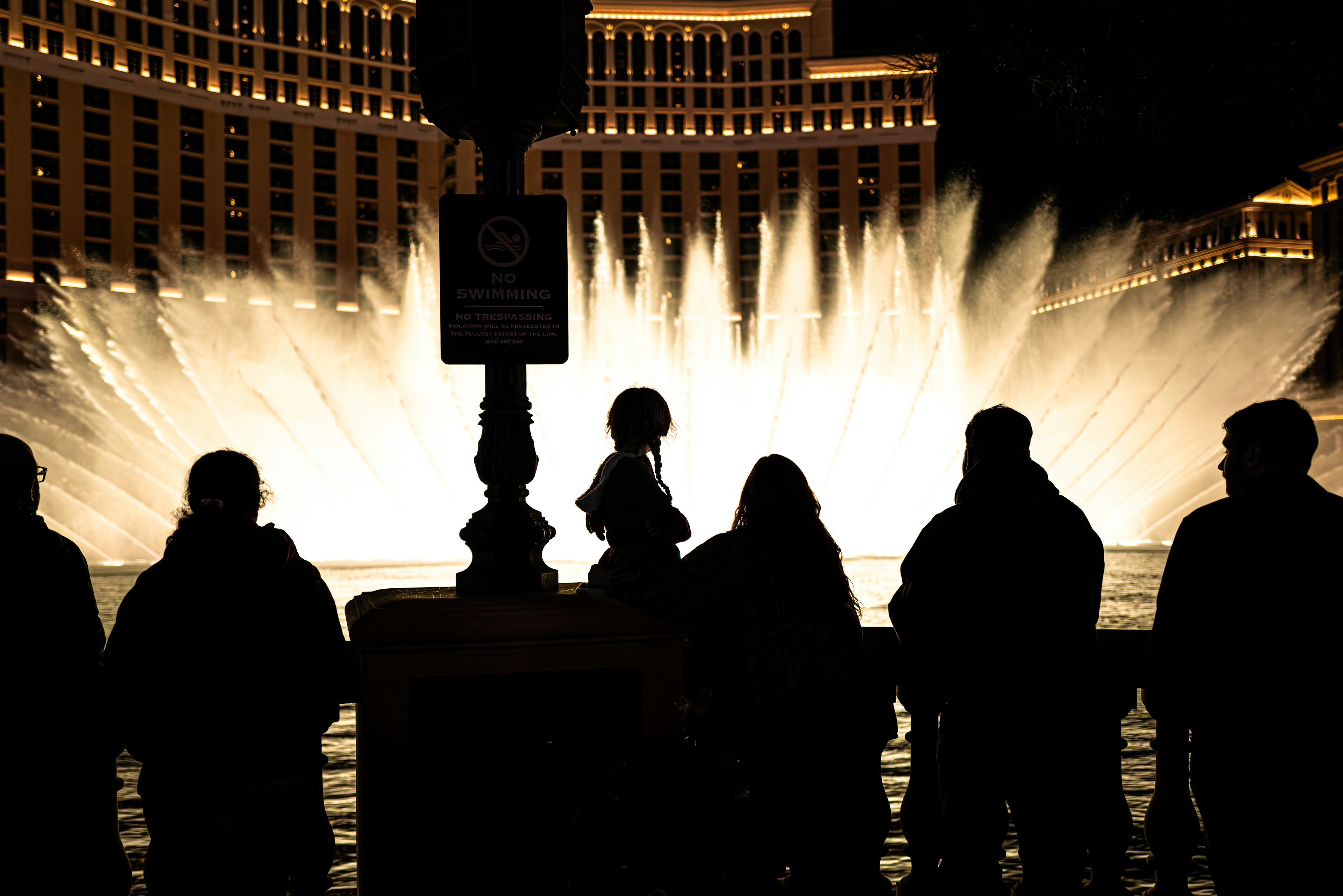 Silhouetten von Menschen, die die Bellagio-Quelle bei Nacht beobachten