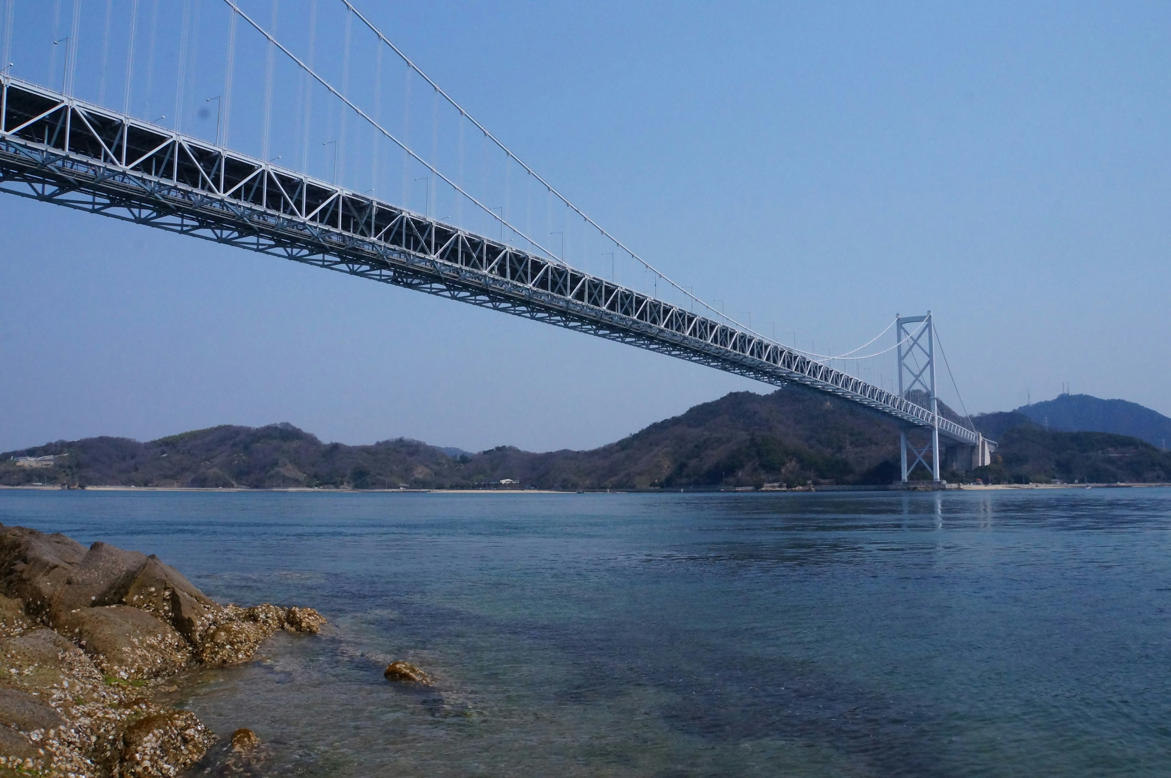 Bridge spanning over calm waters with distant mountains