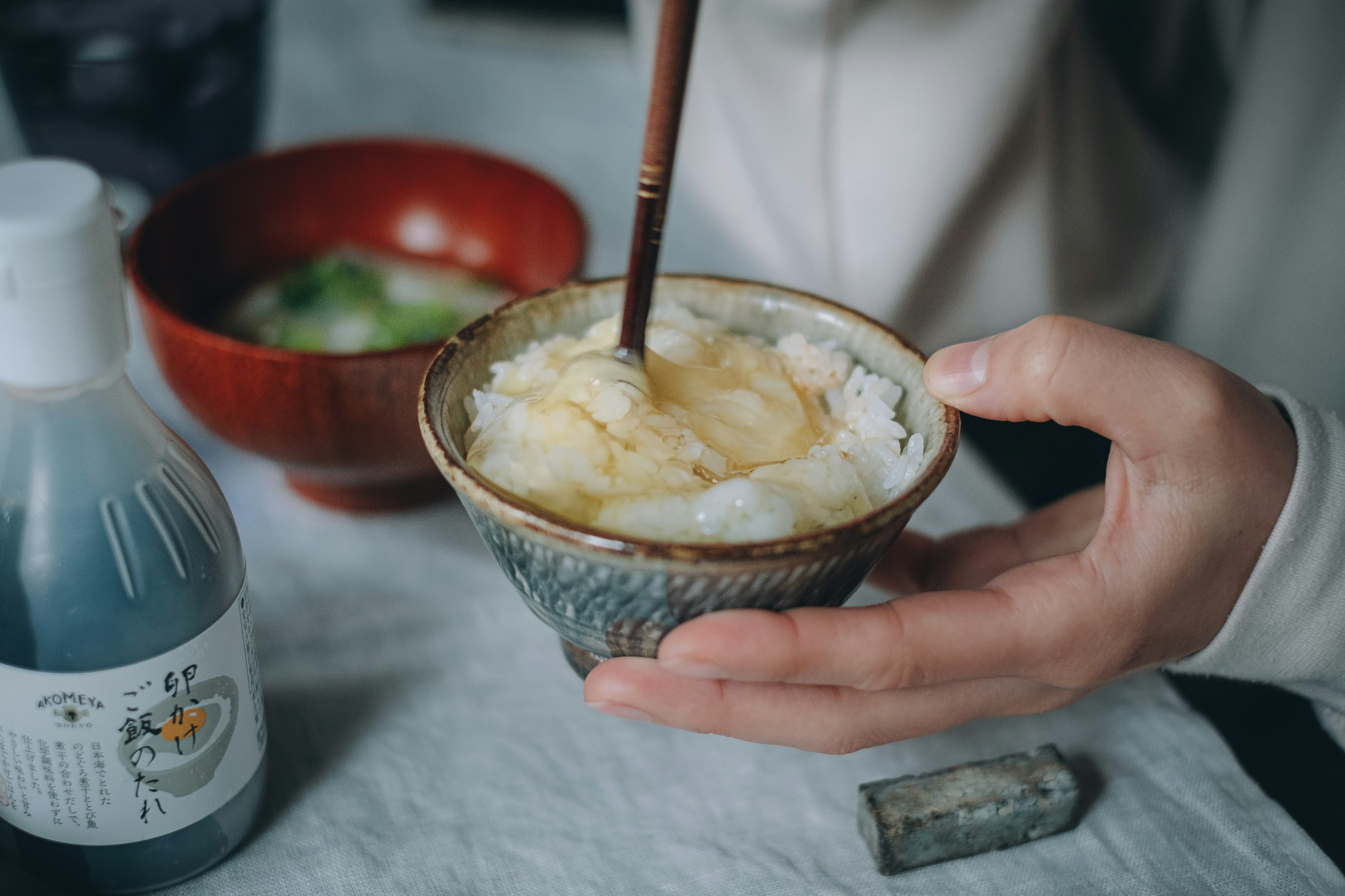 碗中盛着温暖的米饭，正在用木勺搅拌