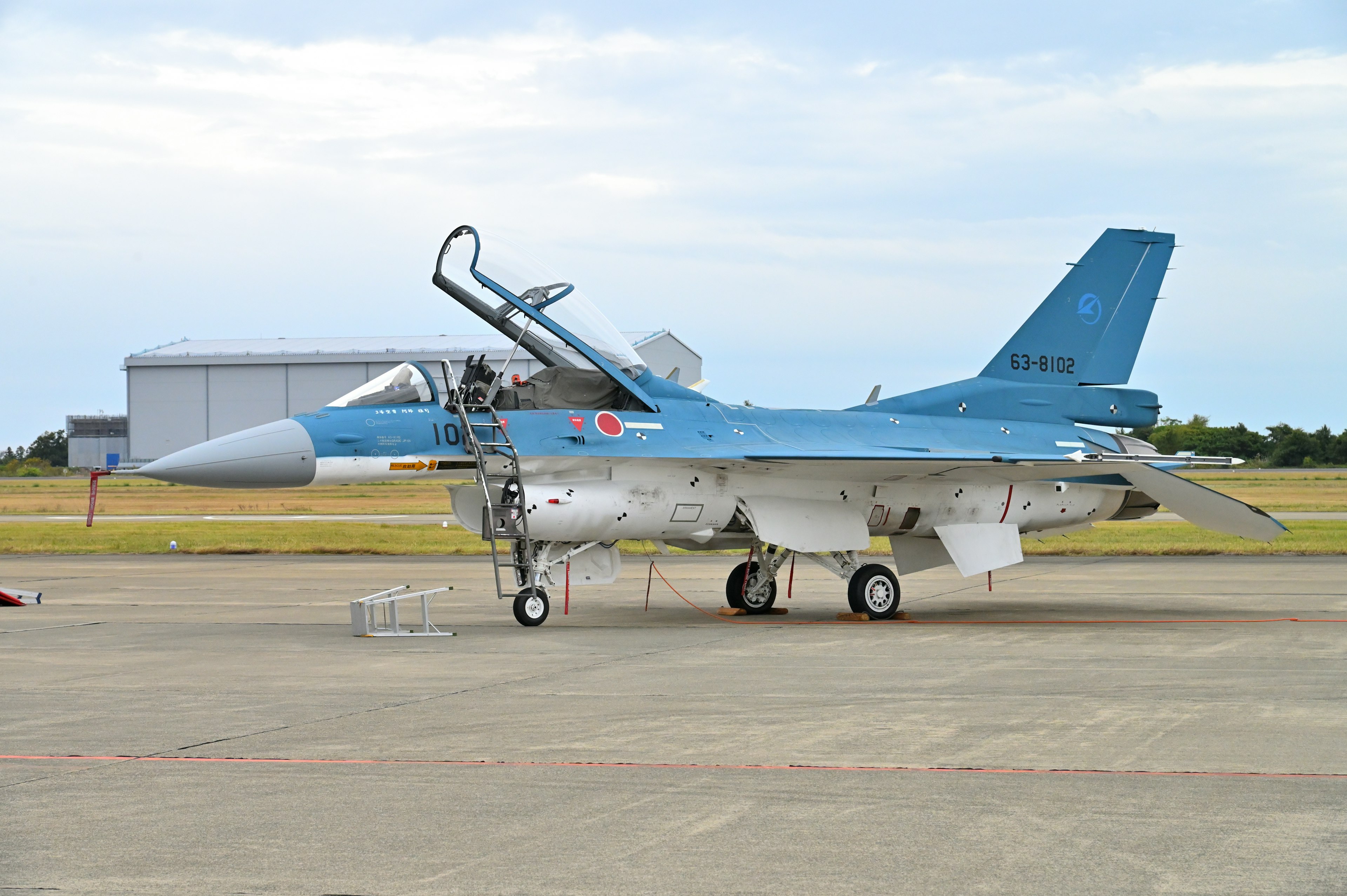 A blue-painted fighter jet parked on the runway