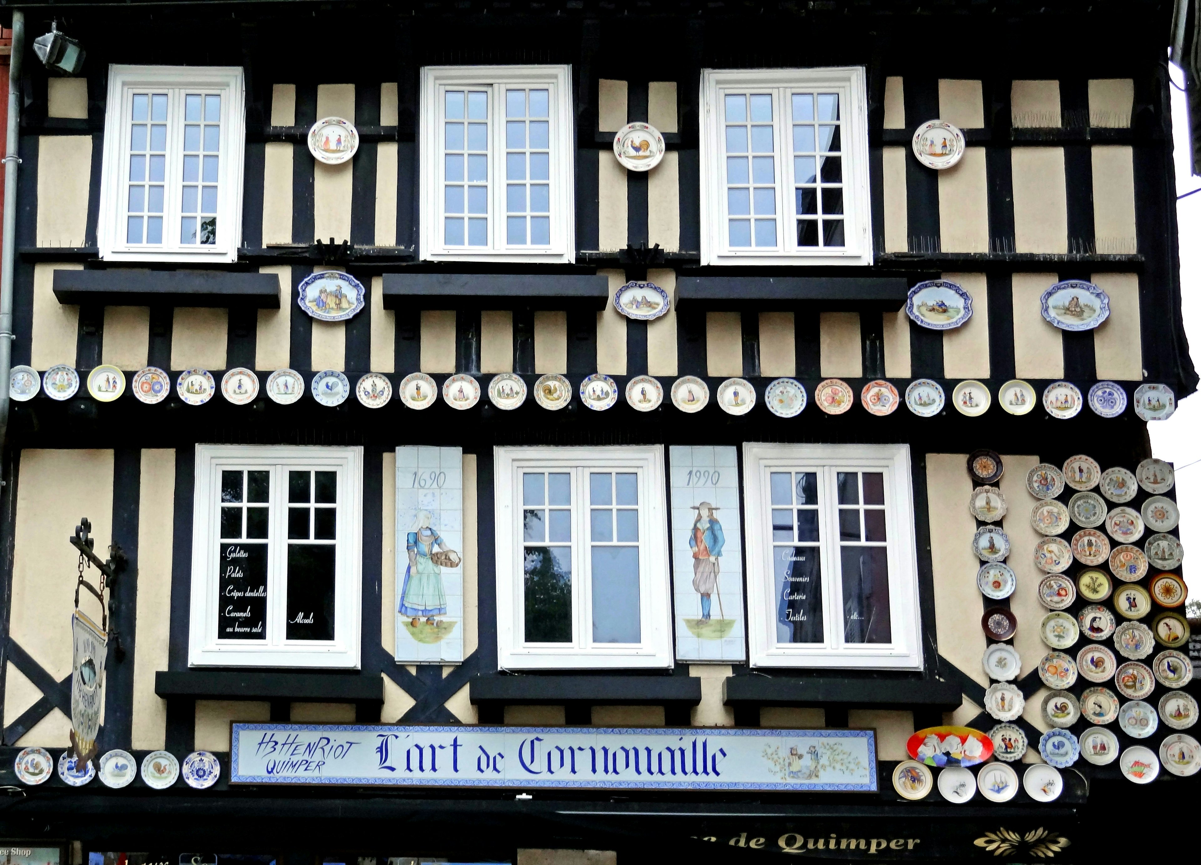 Half-timbered house exterior with white windows and decorative plates