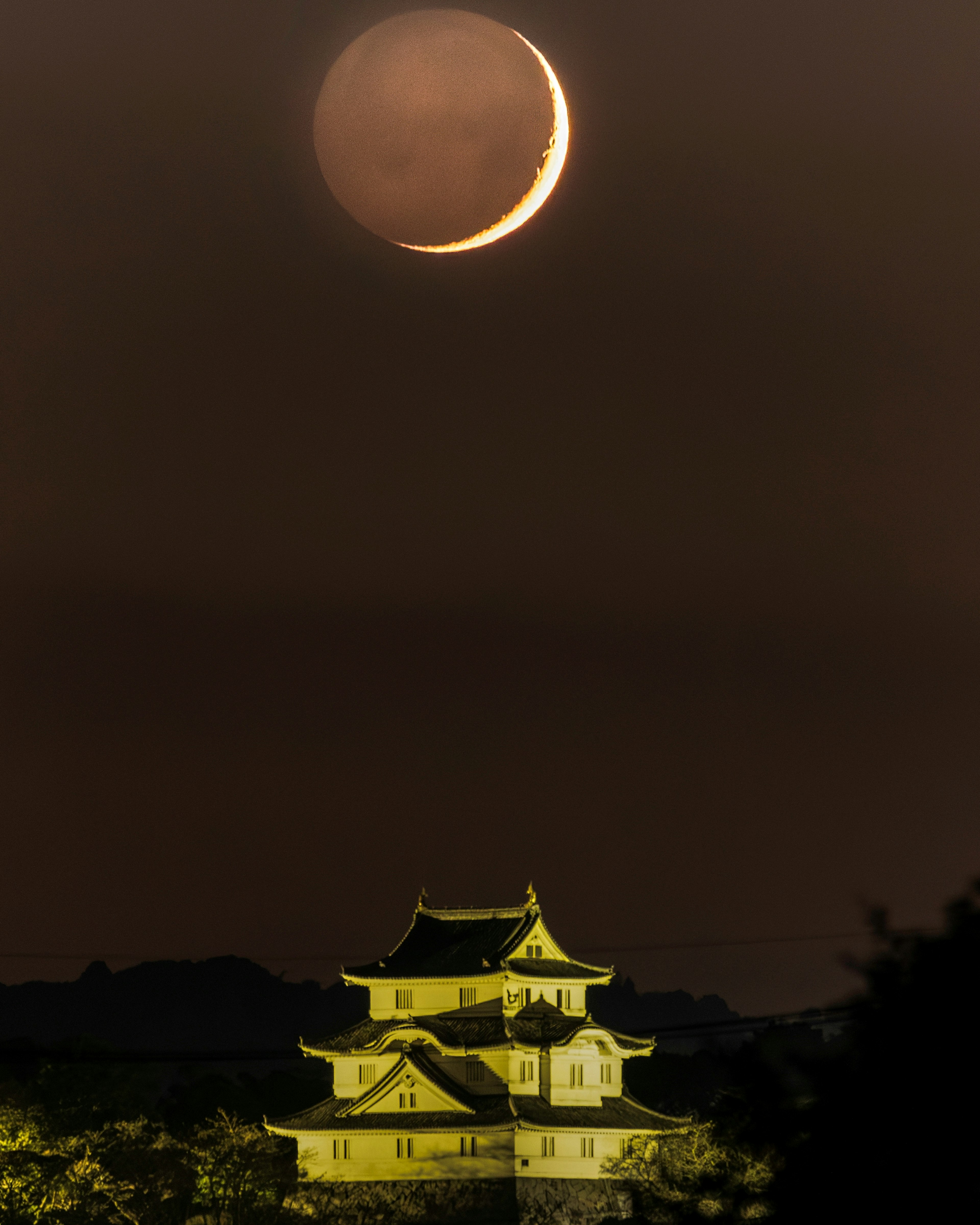 Beeindruckende Nachtansicht eines Schlosses unter einem zunehmenden Mond