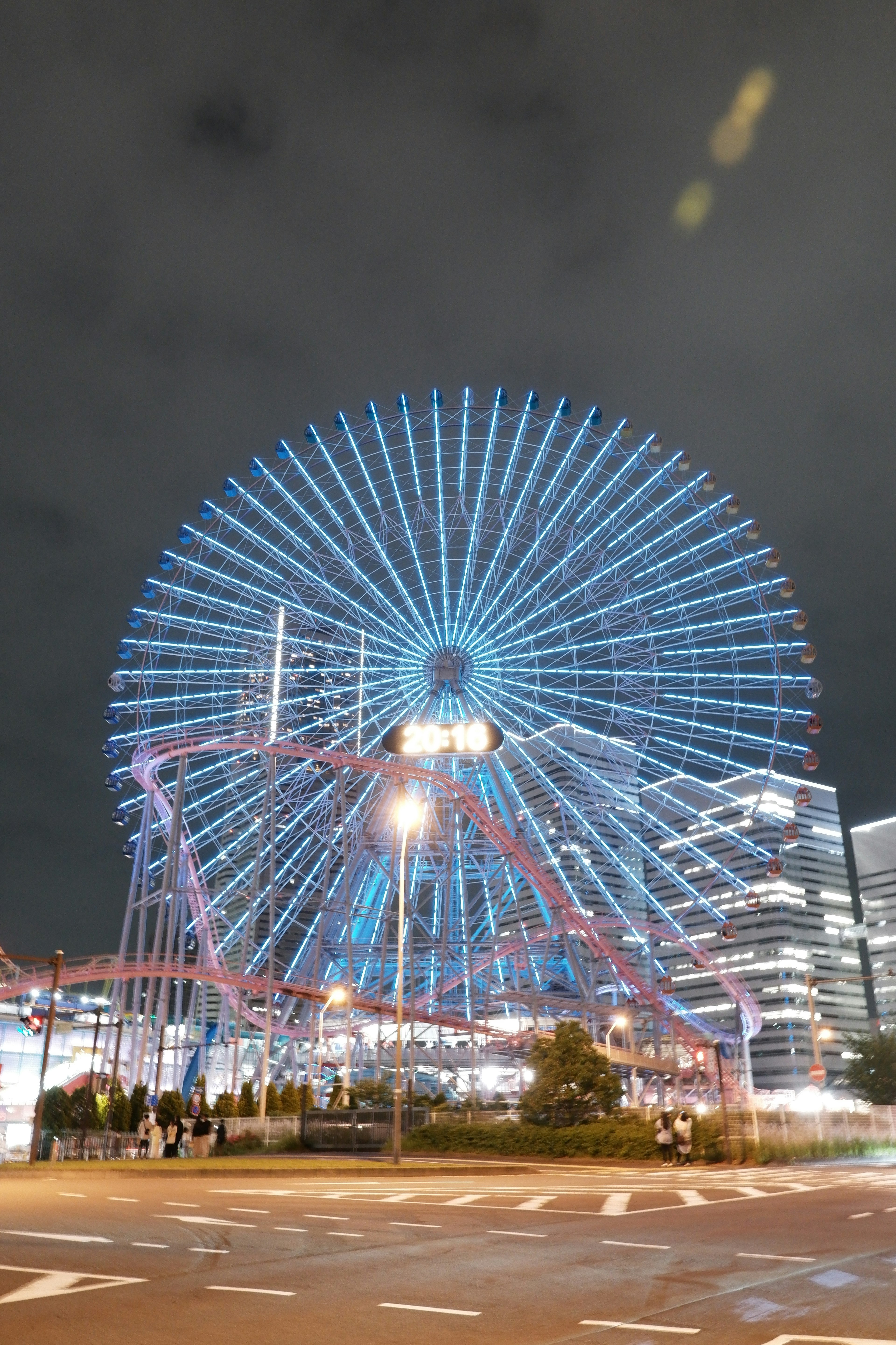 Vue nocturne d'une grande roue illuminée de lumières bleues