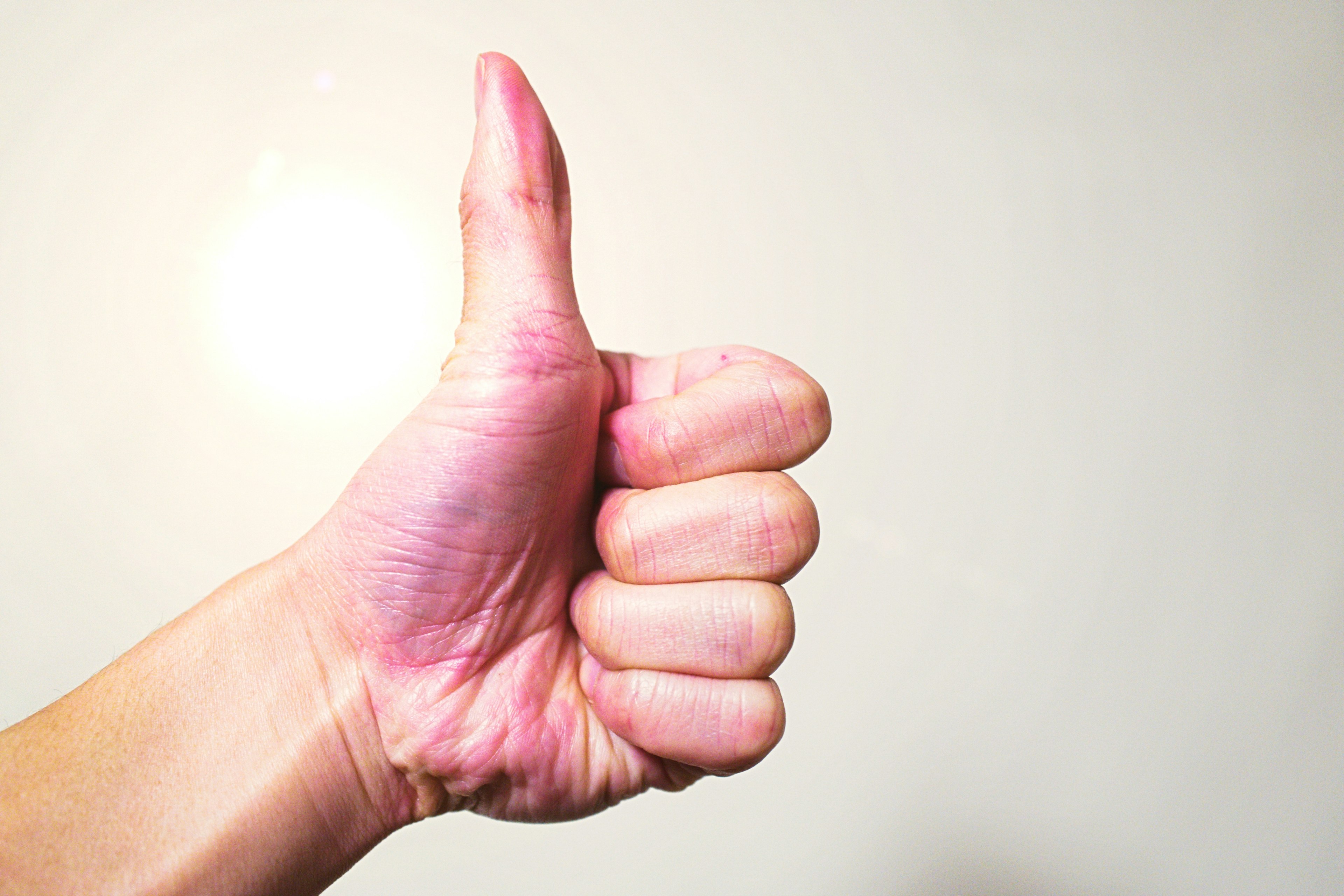 Image of a hand giving a thumbs up with a light background