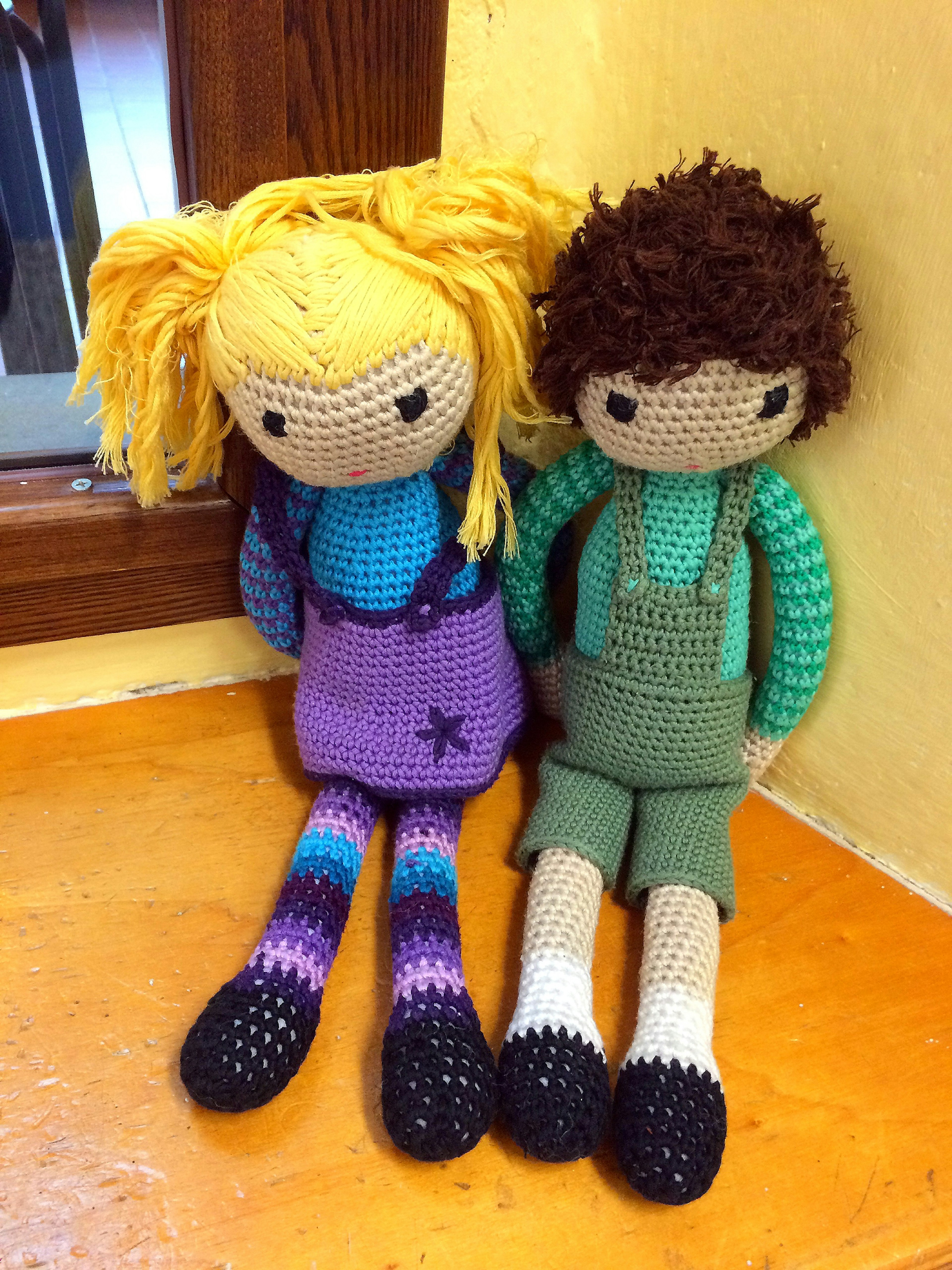 Colorful crocheted dolls sitting side by side