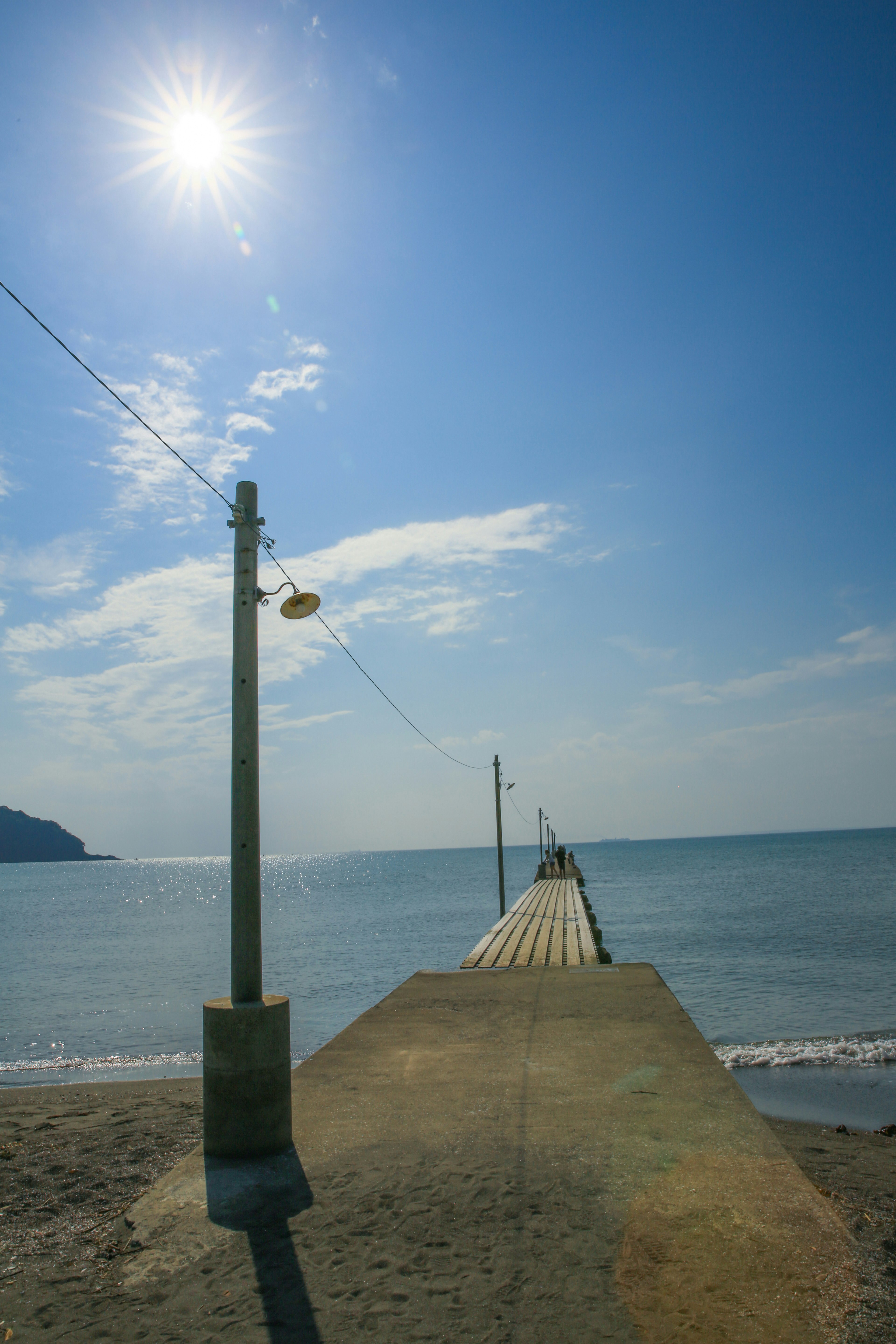 Una vista de un muelle que se extiende hacia el mar azul bajo un cielo brillante