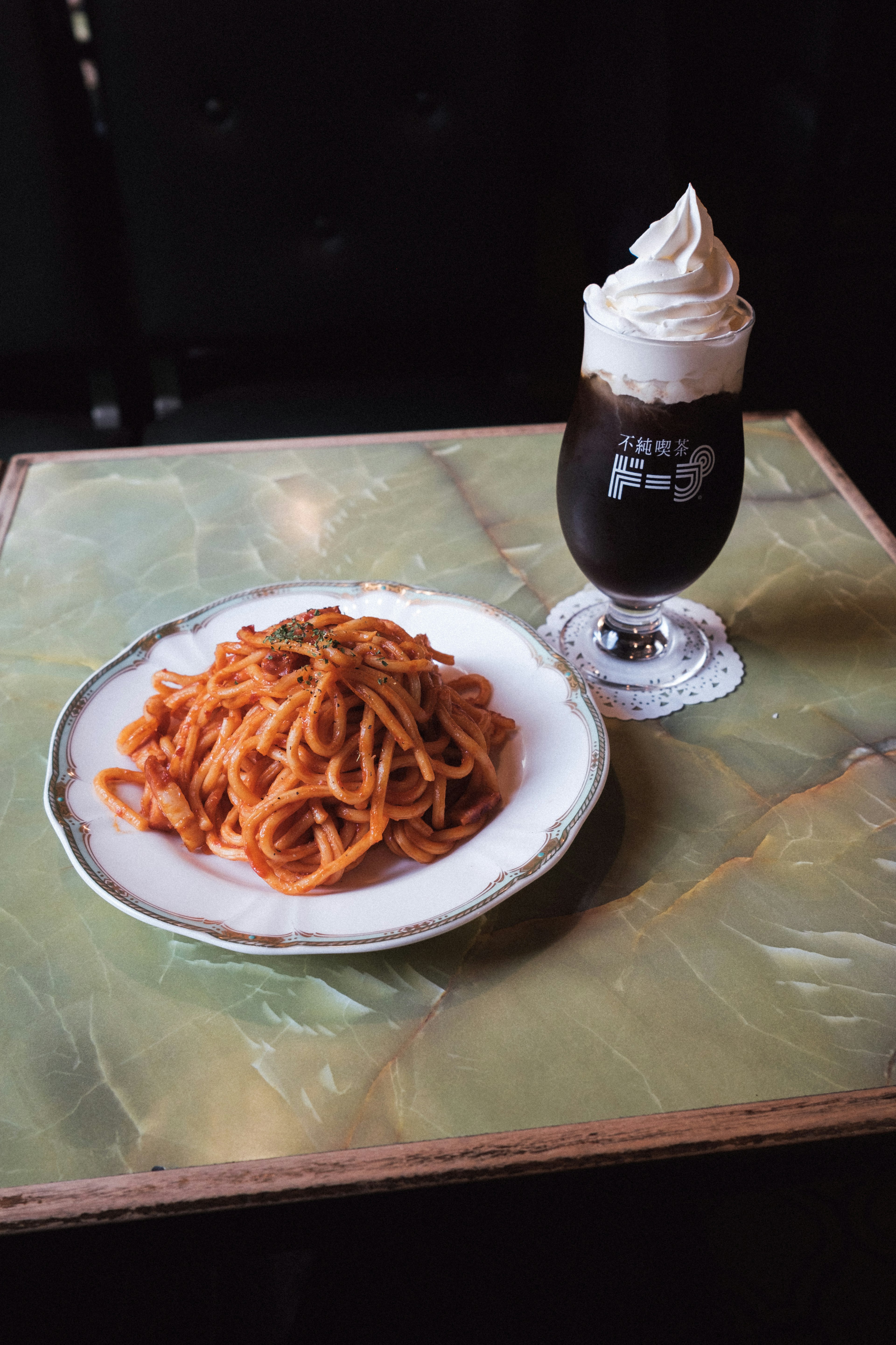 Assiette de spaghetti napolitain et un verre de café surmonté de crème fouettée