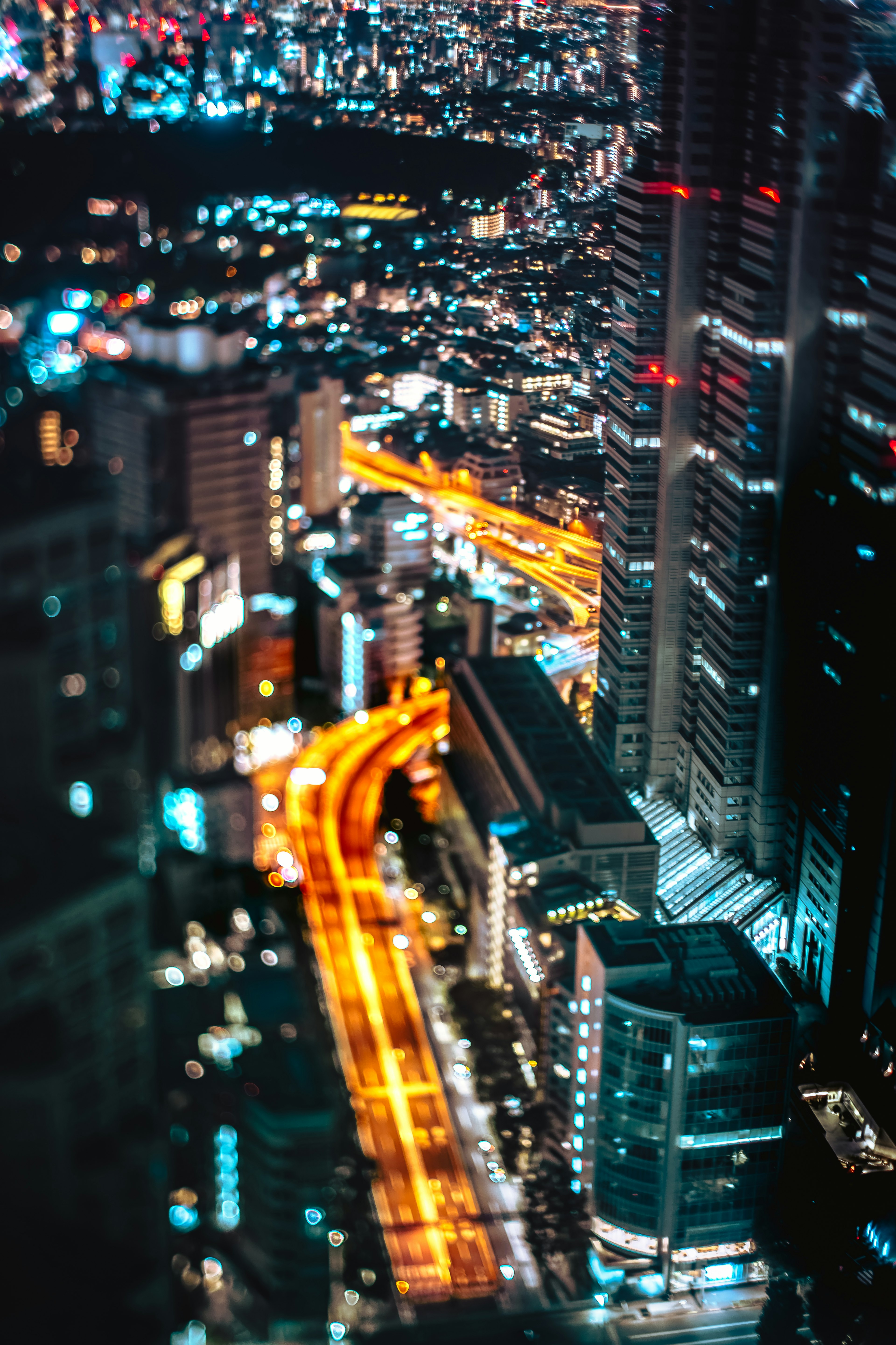 夜景が美しい都市の上空からの眺めで、明るい道路と高層ビルが見える