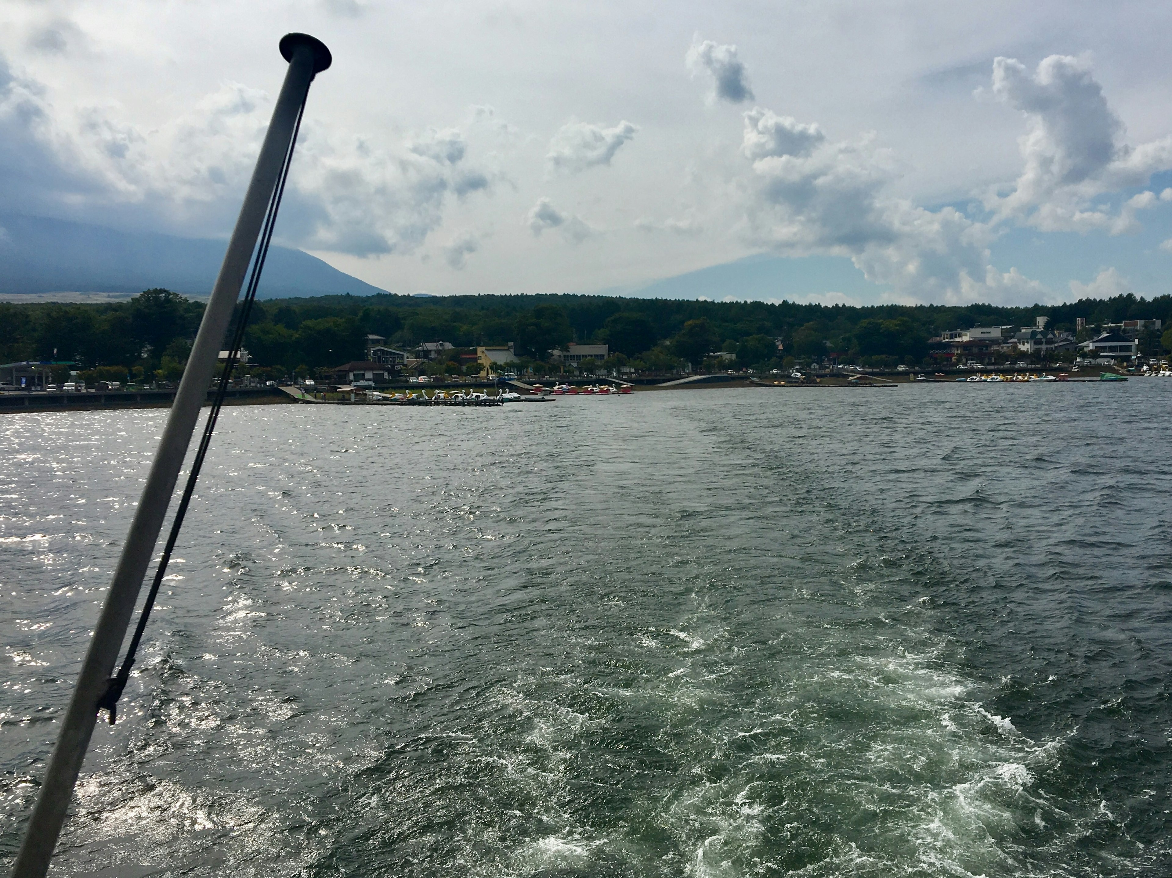 View of the sea and shoreline from the back of a boat