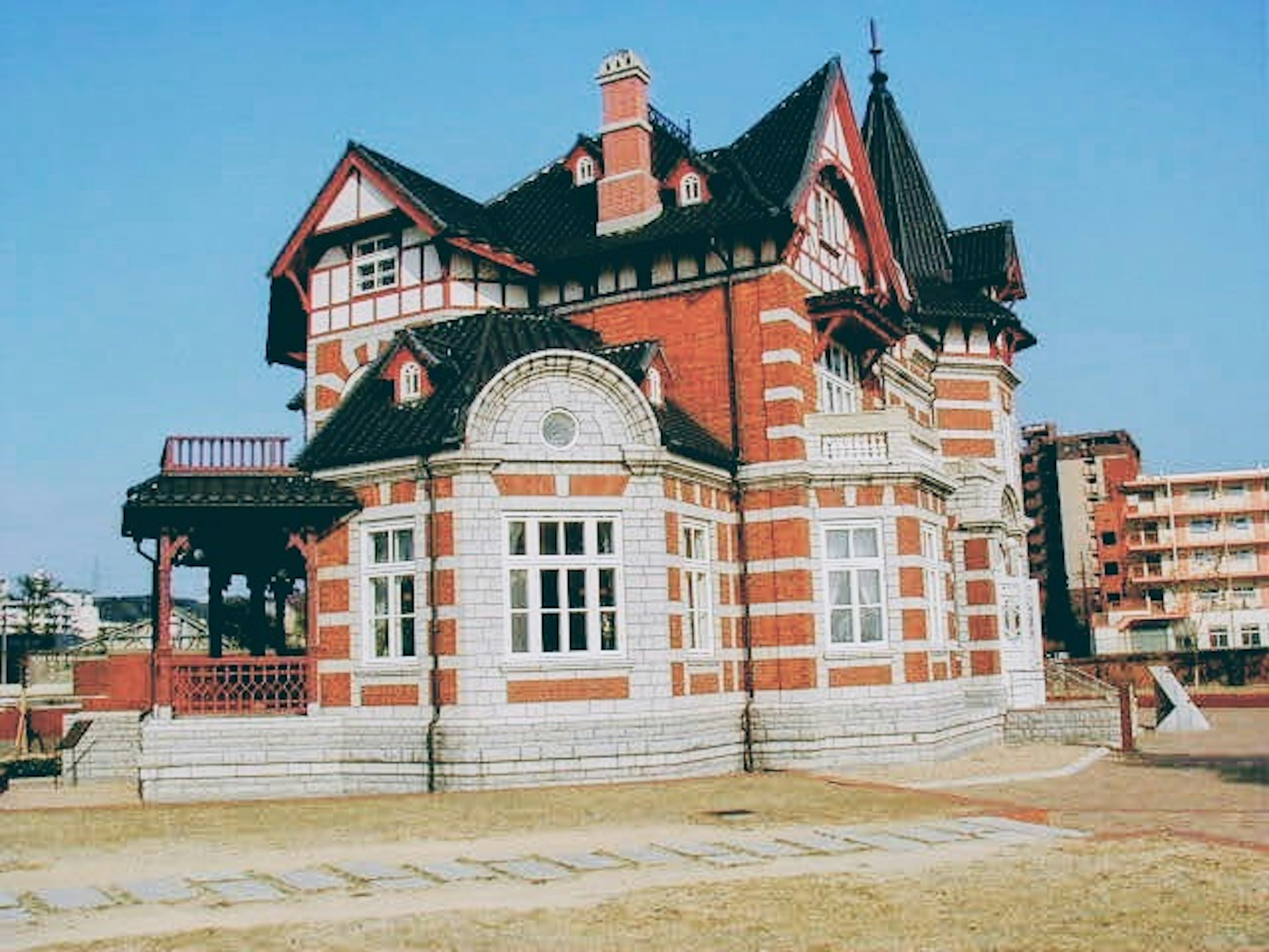 Victorian-style house with striking red bricks and distinctive roof design