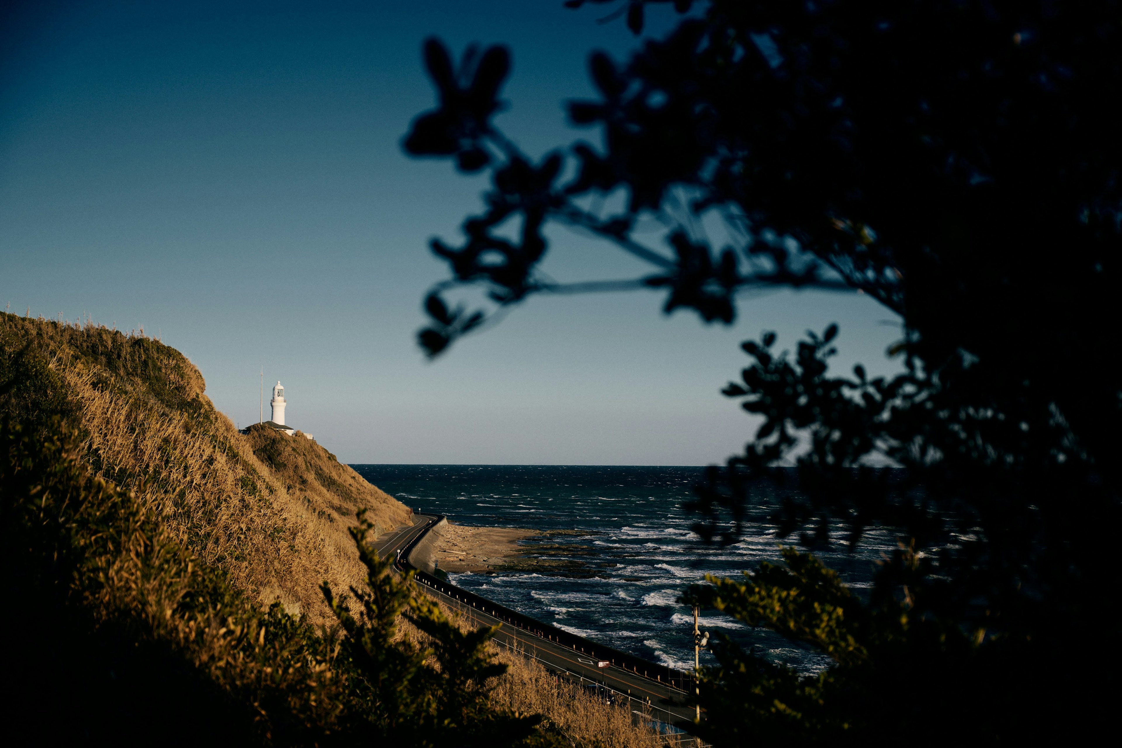 Scena costiera con un faro al crepuscolo