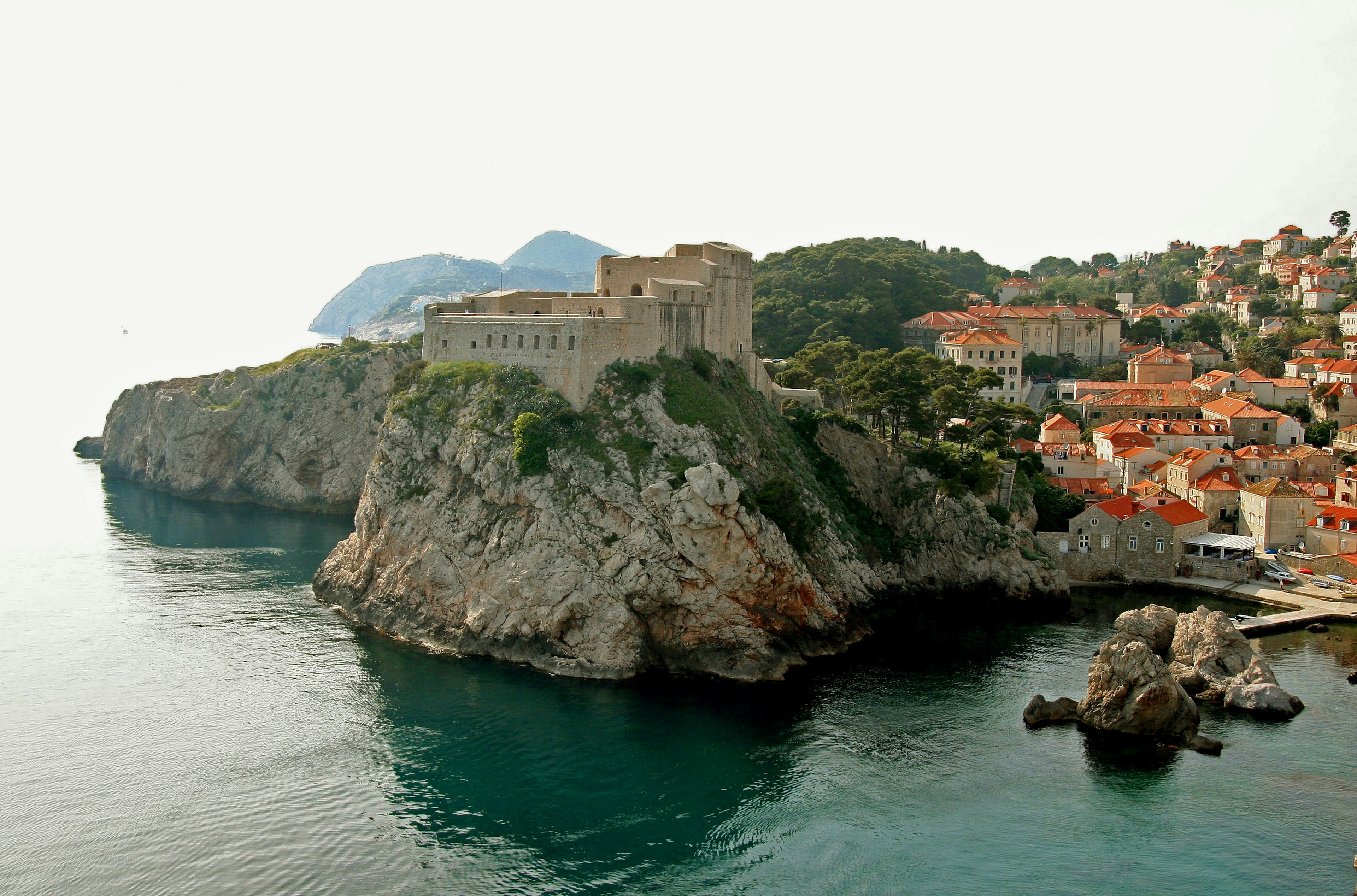 Castello affacciato sul mare con una città costiera vicina