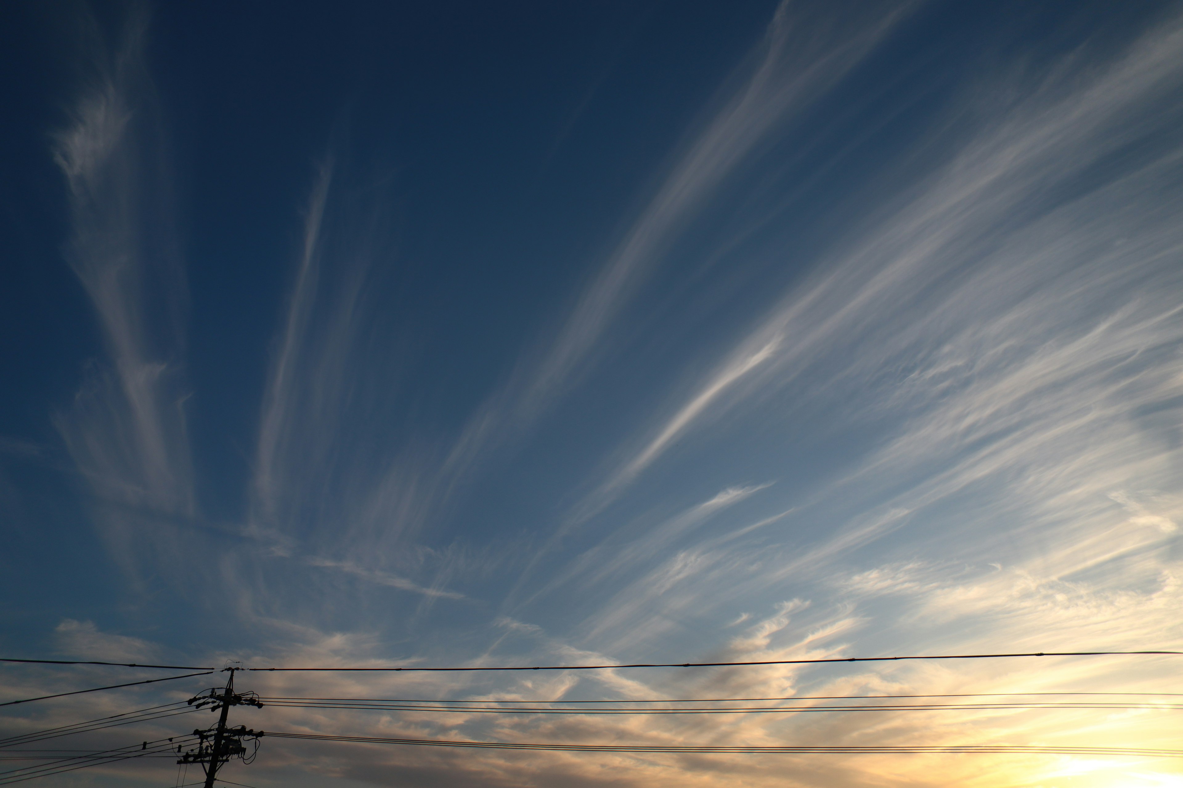 Beautiful cirrus clouds spread across the blue sky with sunset light