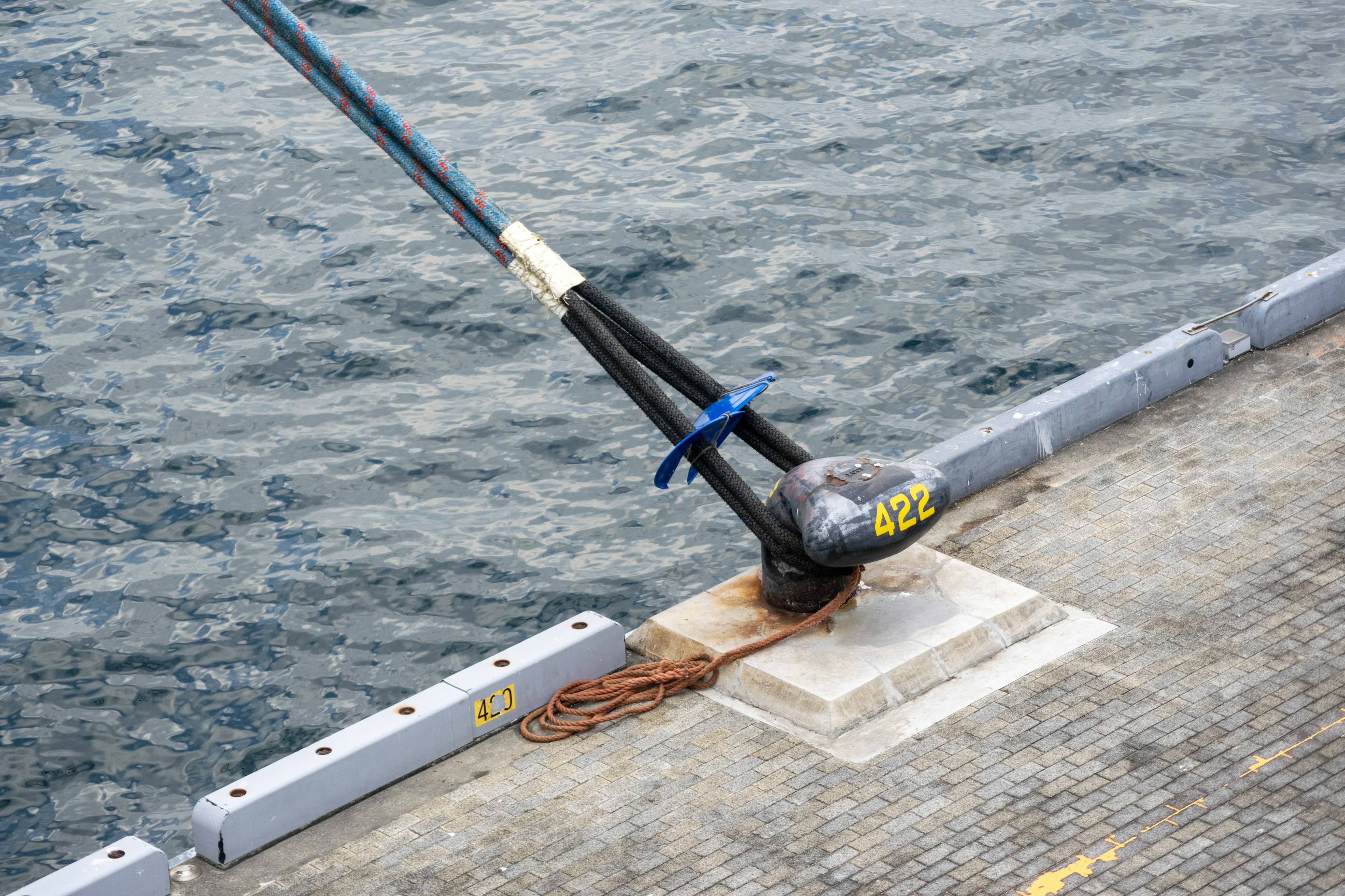 Docking cleat with a blue rope near the water surface