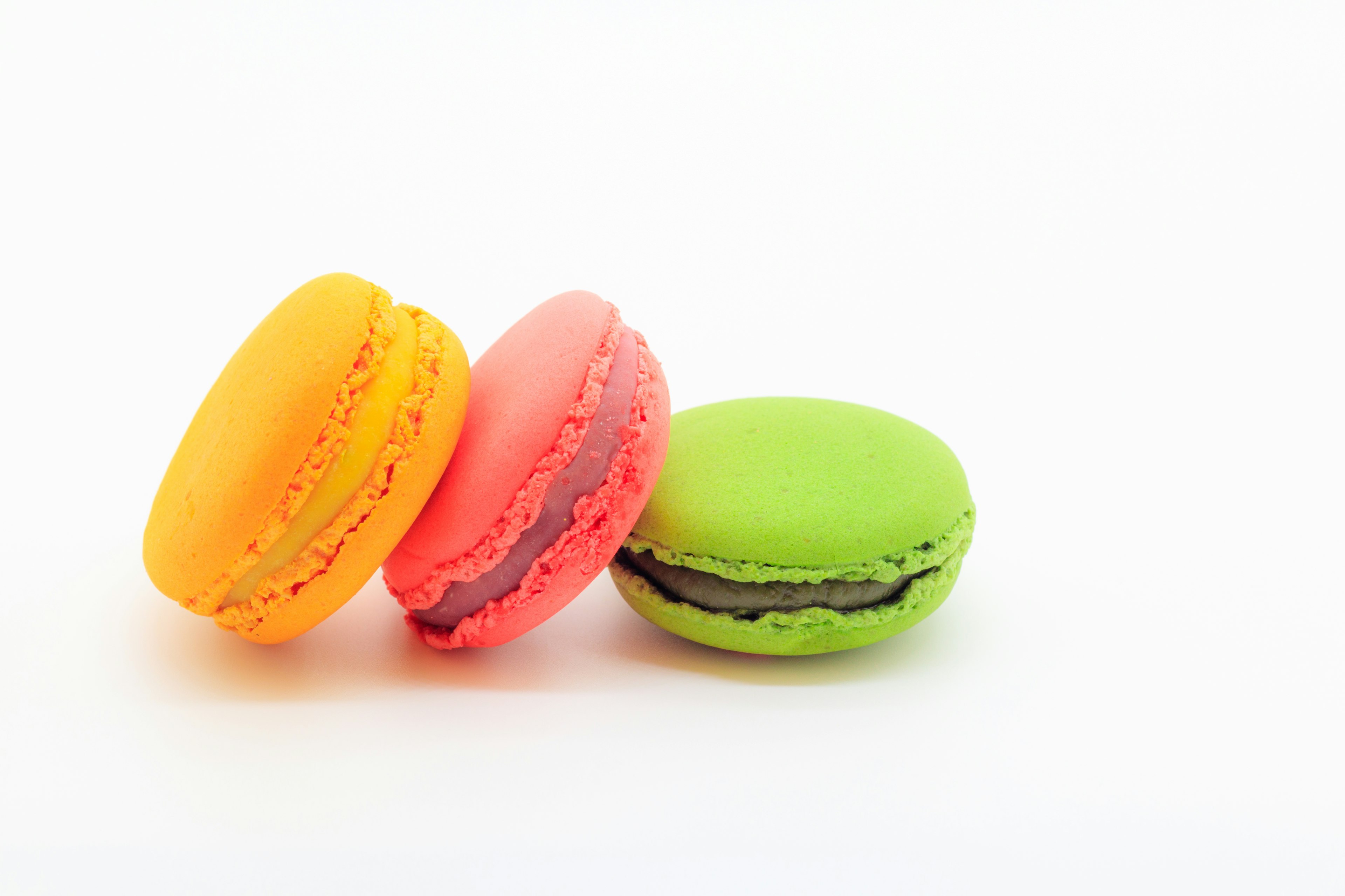 Three colorful macarons arranged on a white background