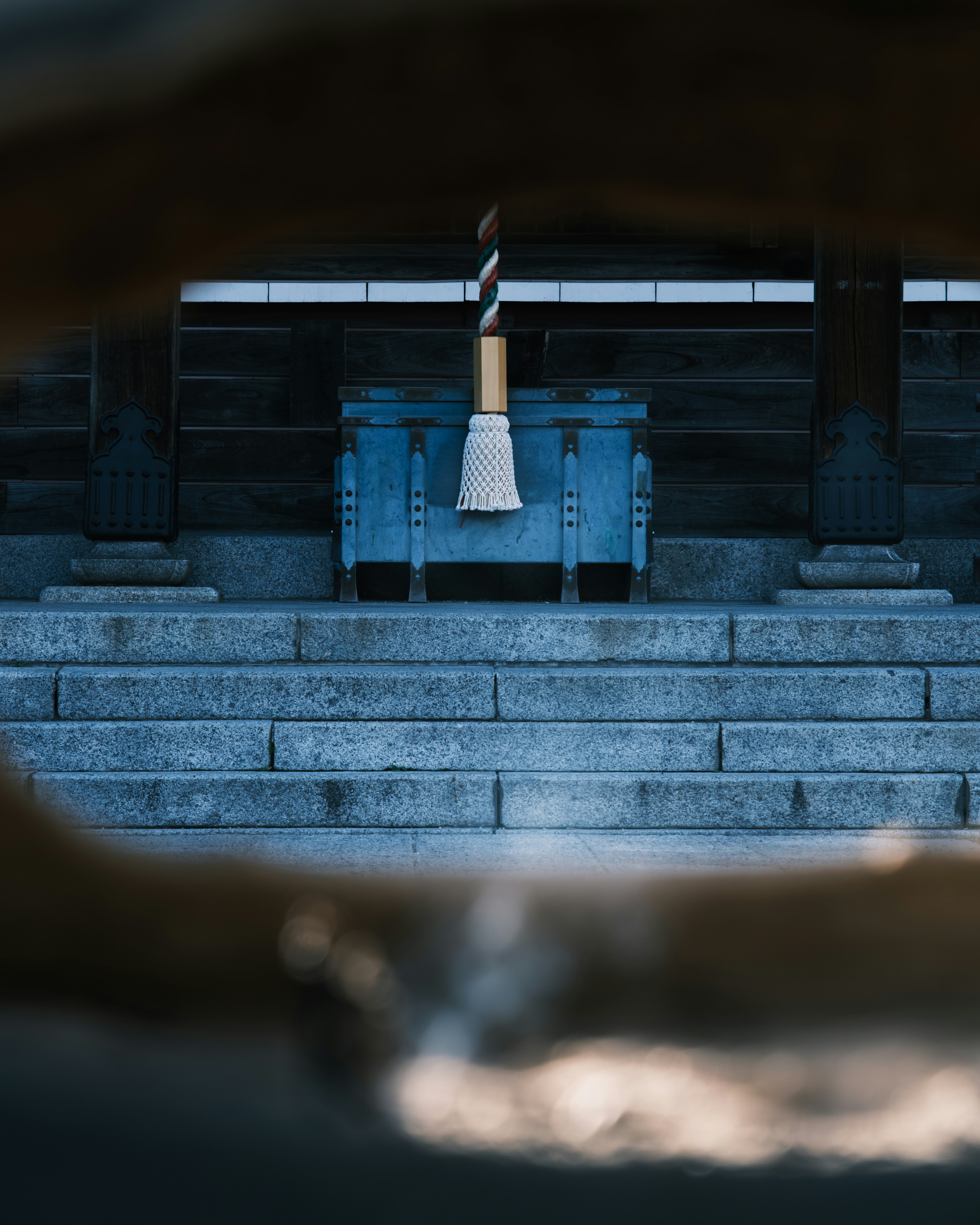 Una escena de santuario con un altar azul y una escoba visible a través de un marco