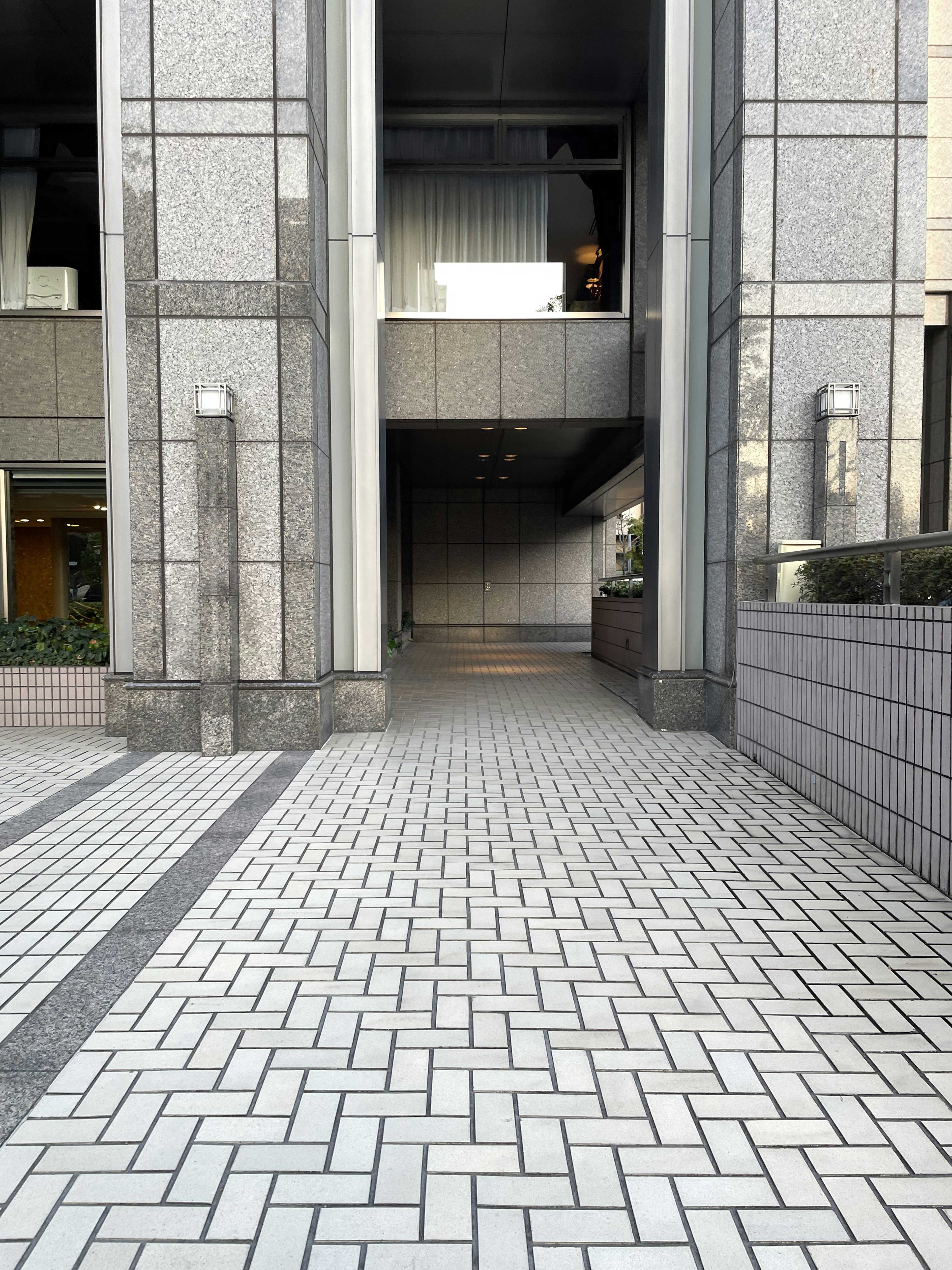 Entrée d'un grand bâtiment avec un chemin carrelé