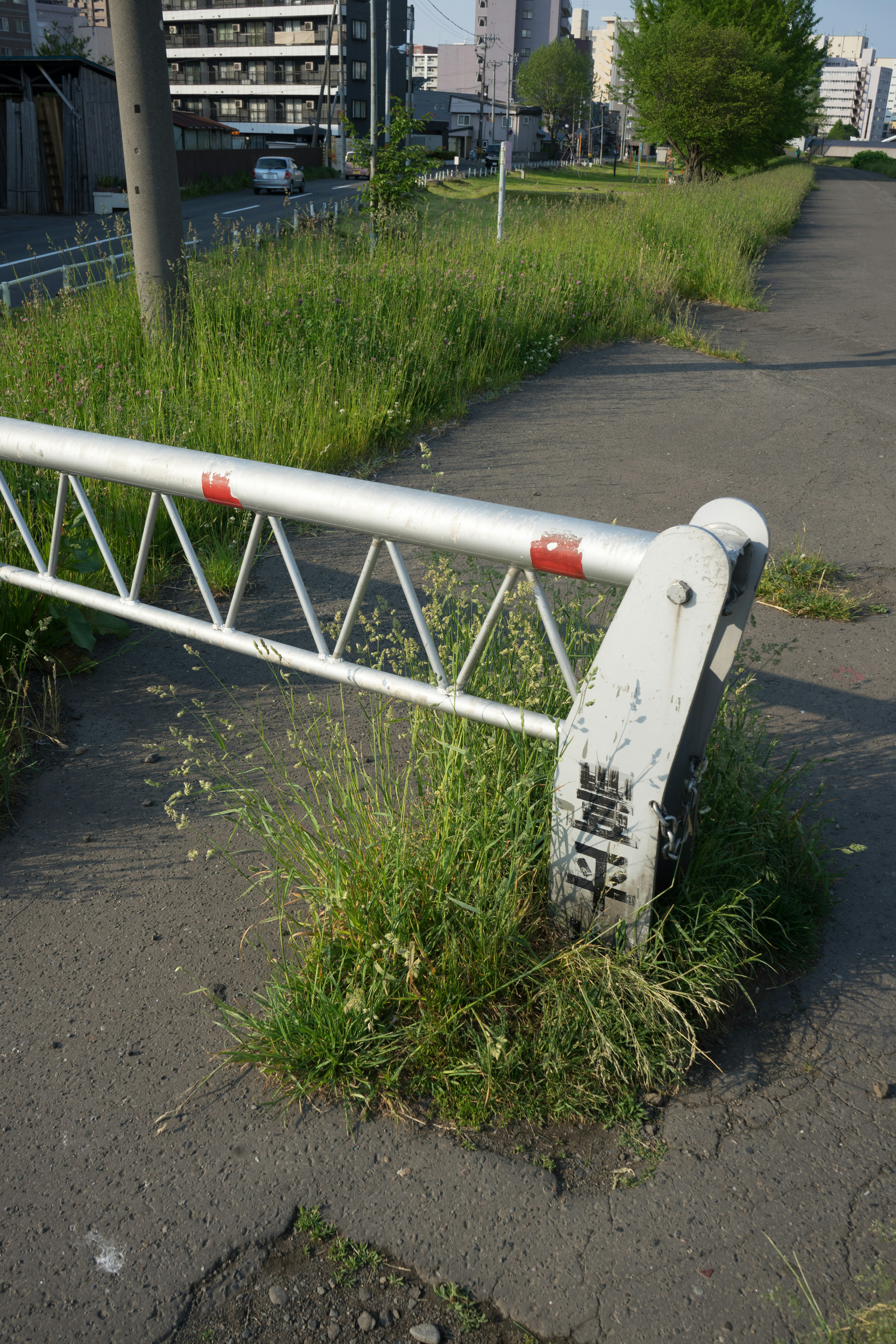 White barrier overgrown with grass and surrounding green landscape