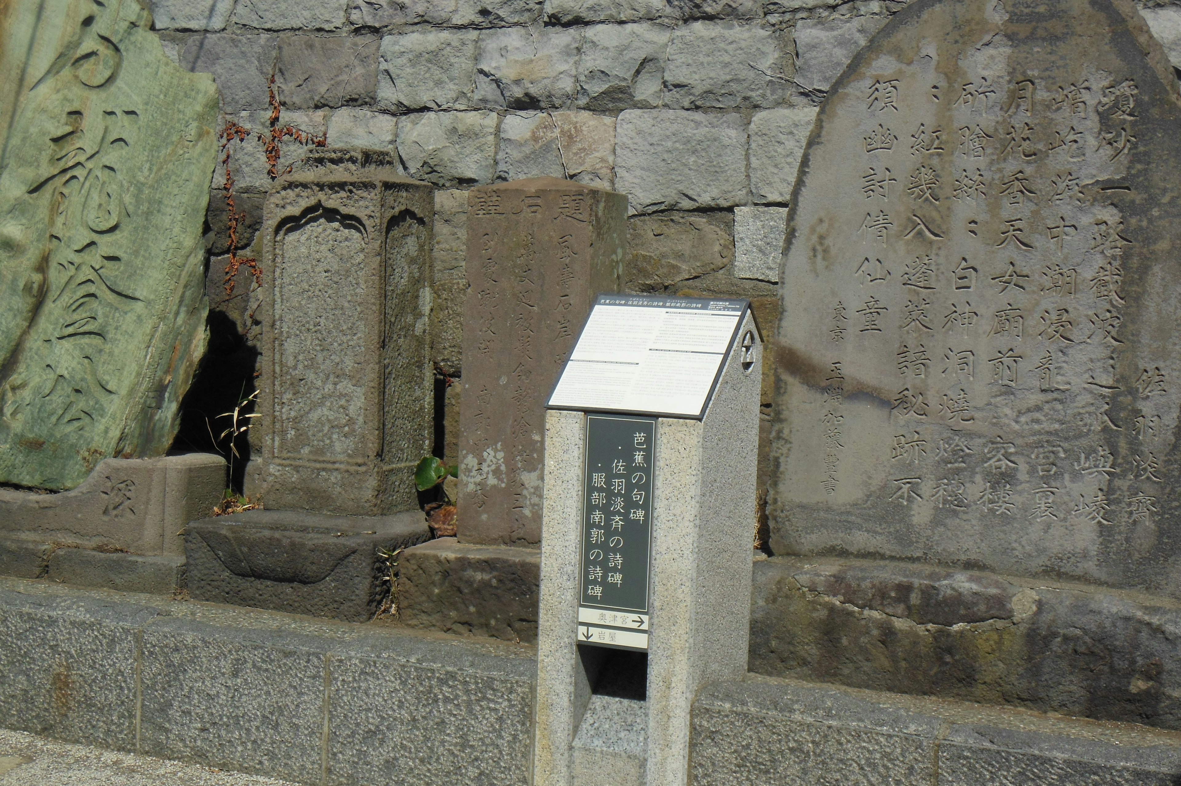 Sitio histórico con monumentos de piedra y un panel informativo