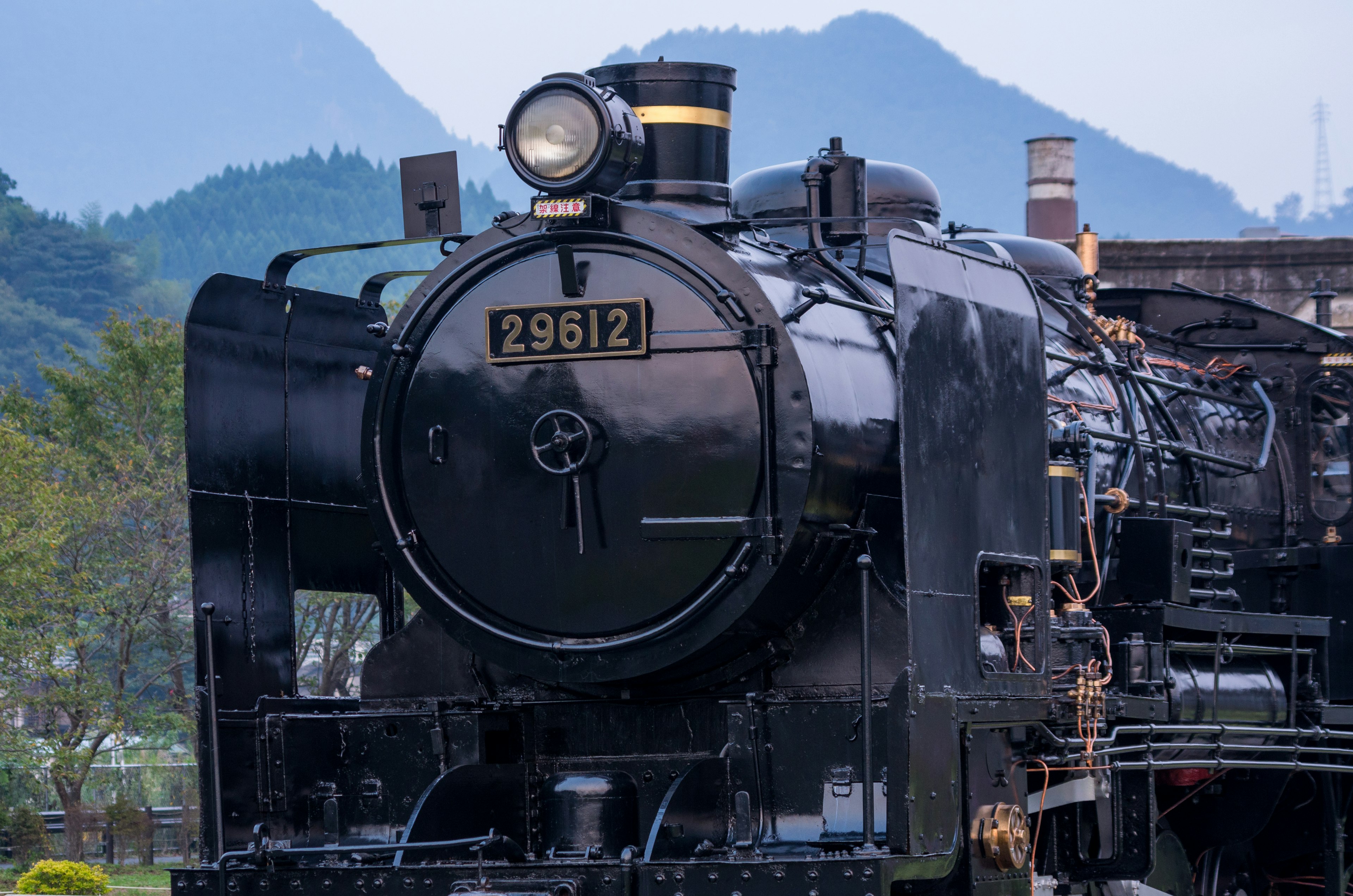 Front view of black steam locomotive 29512 with mountains in the background