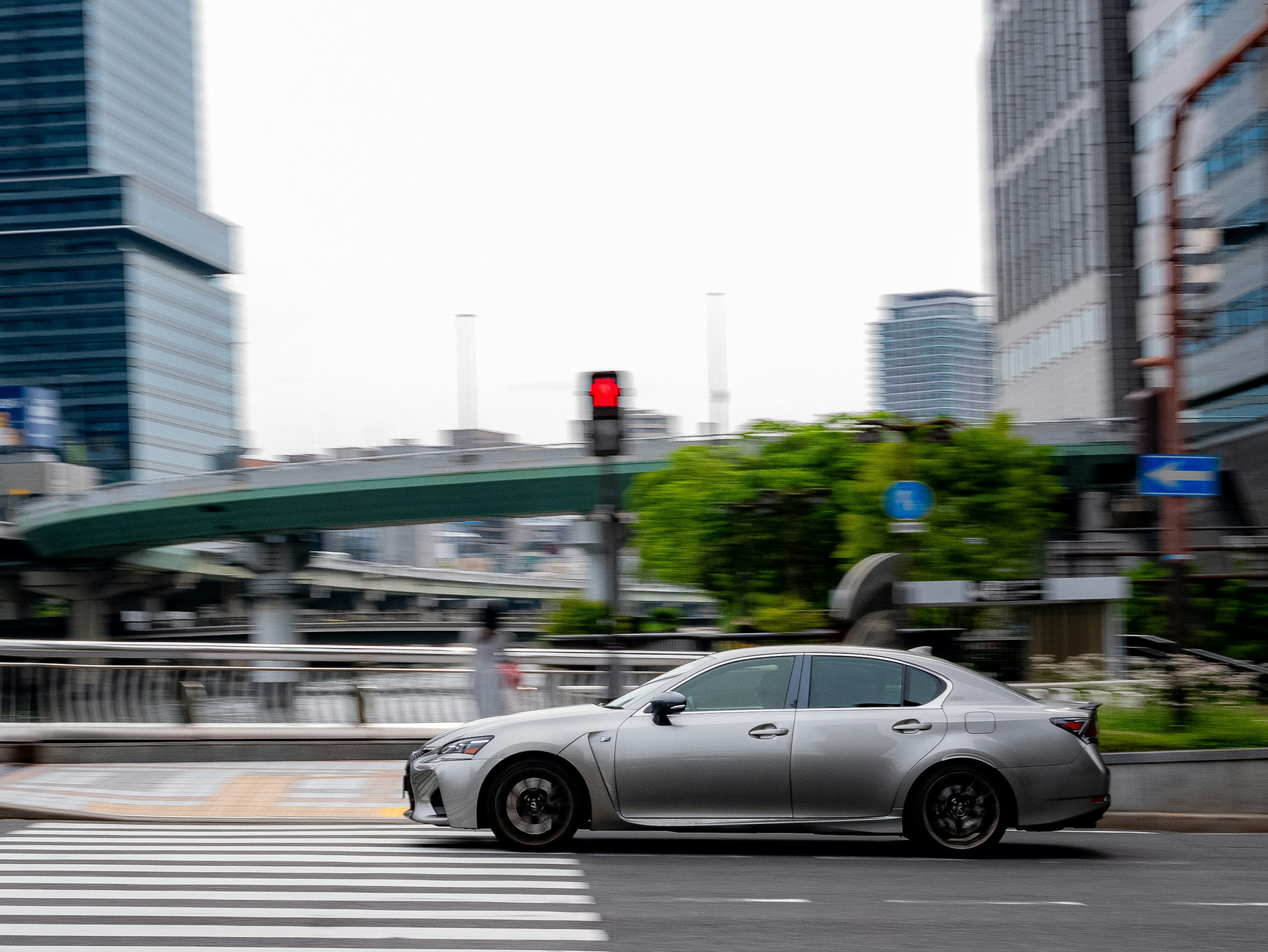 銀色の車が交差点を通過している都会の風景