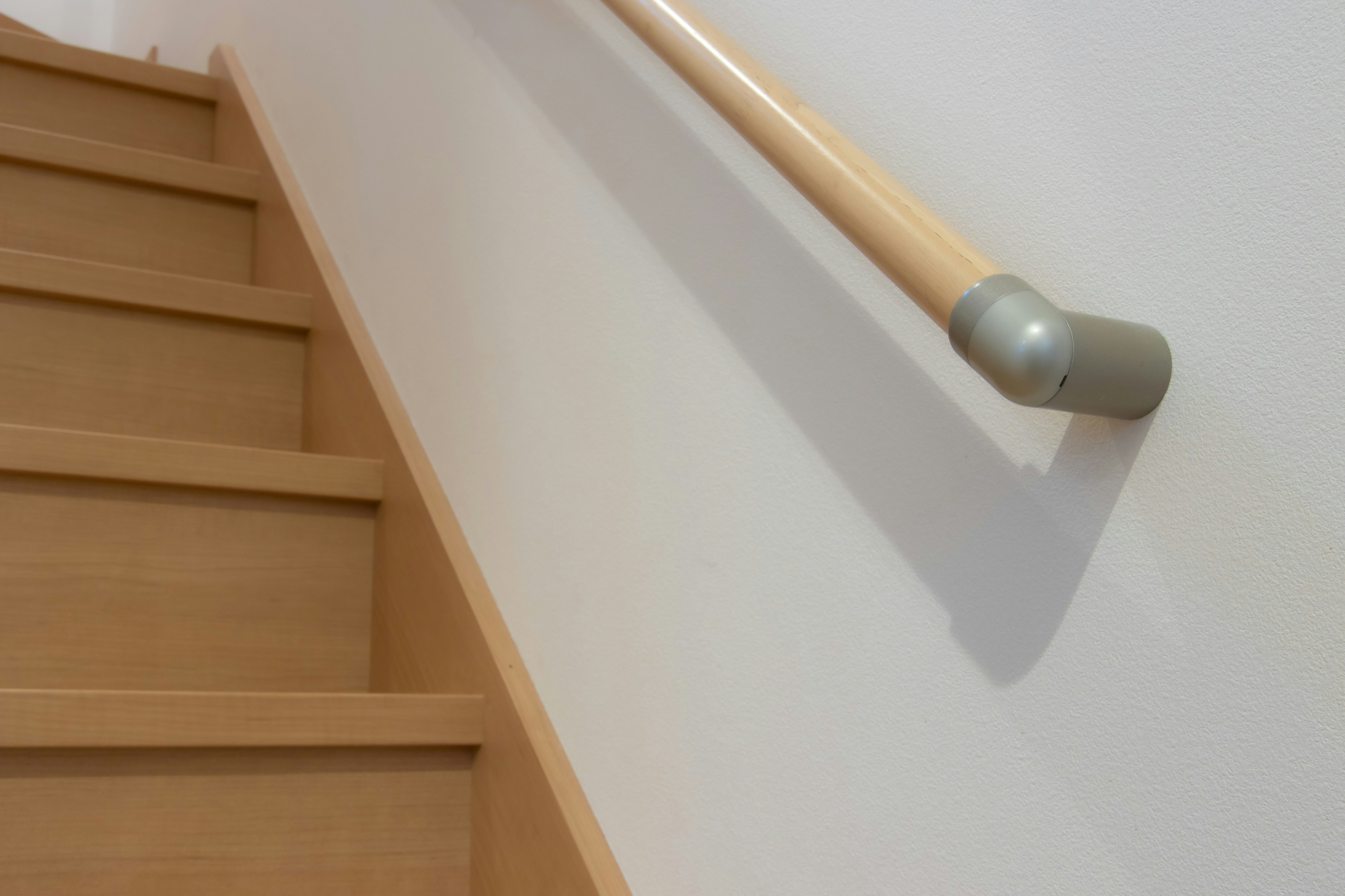 Simple interior view with wooden stairs and handrail