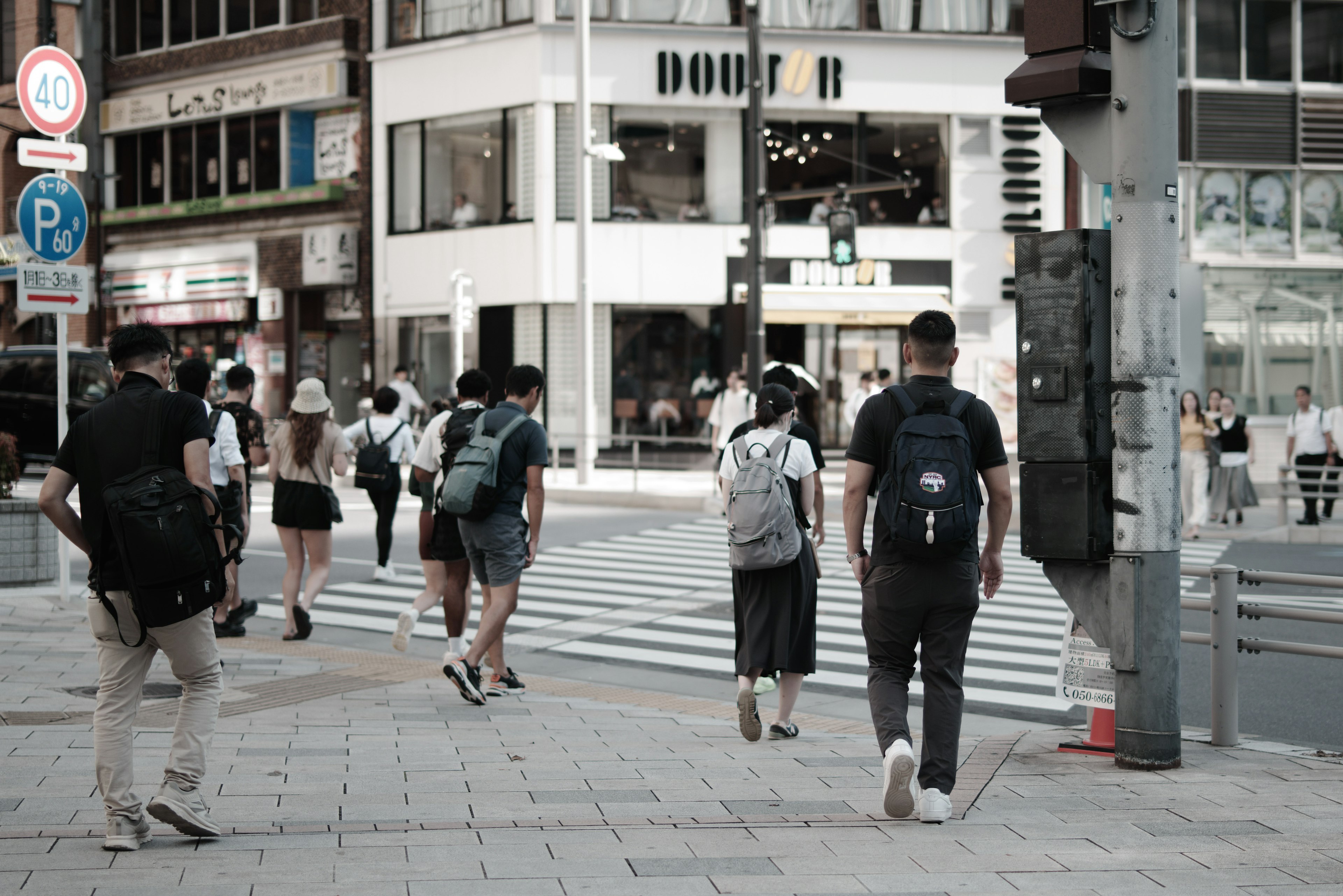 Des gens traversant un passage piéton dans une zone urbaine animée